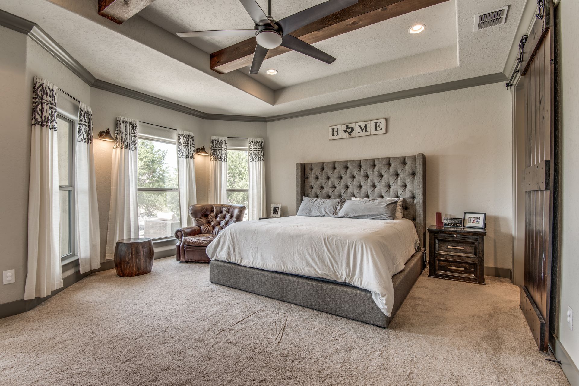 A large bedroom with a king size bed and a ceiling fan.