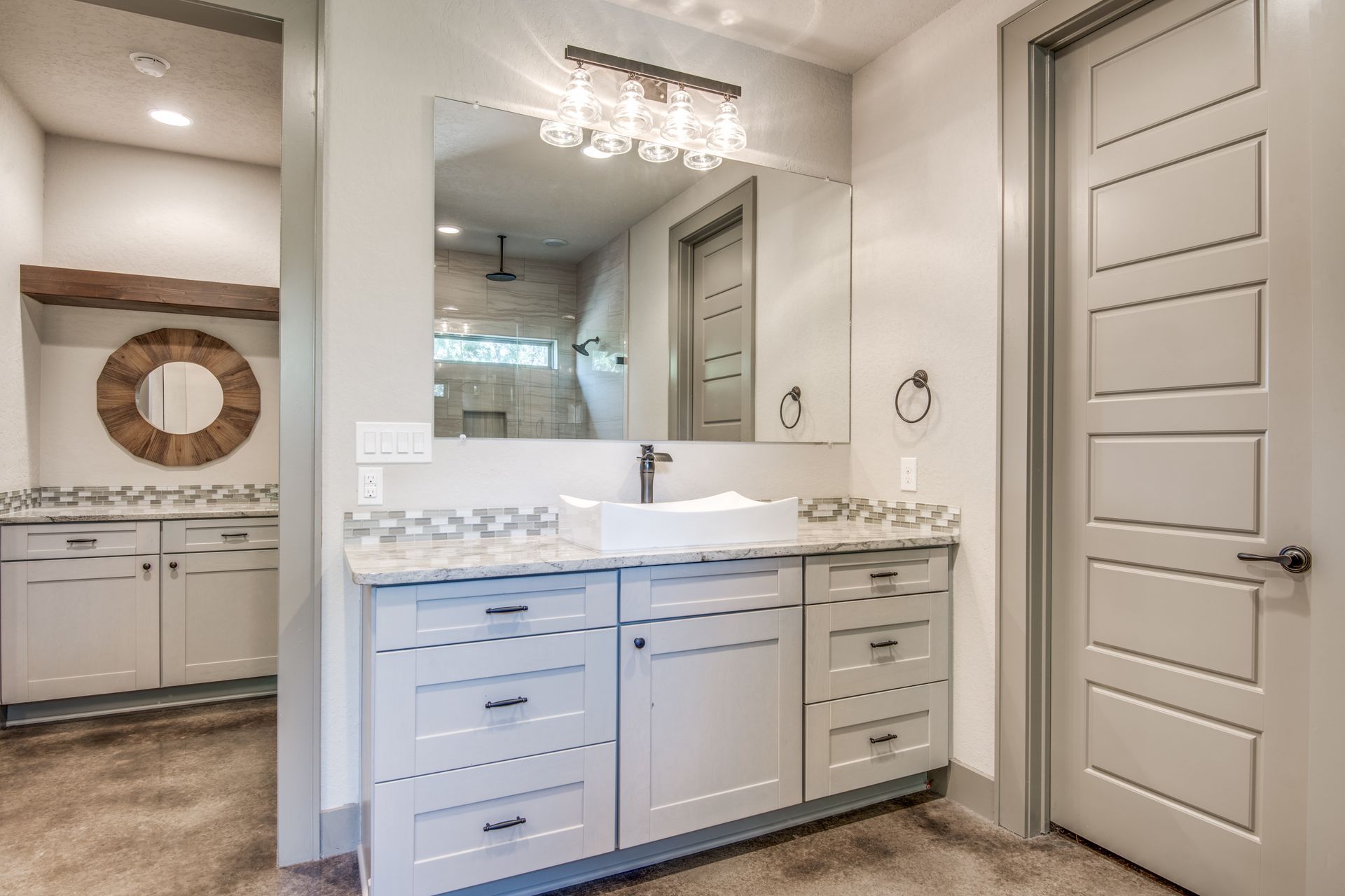 A bathroom with a sink , mirror and cabinets.