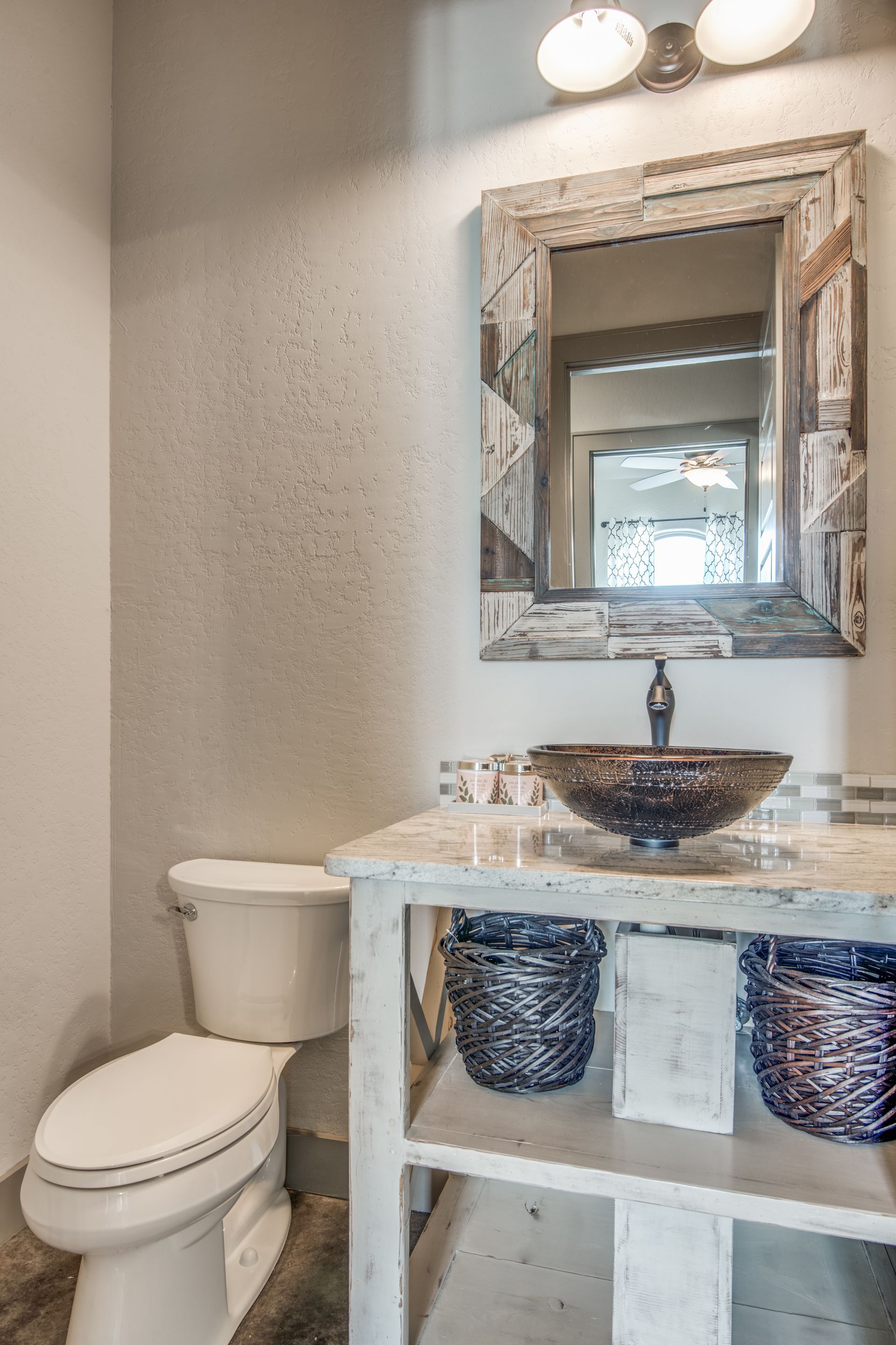 A bathroom with a toilet , sink and mirror.
