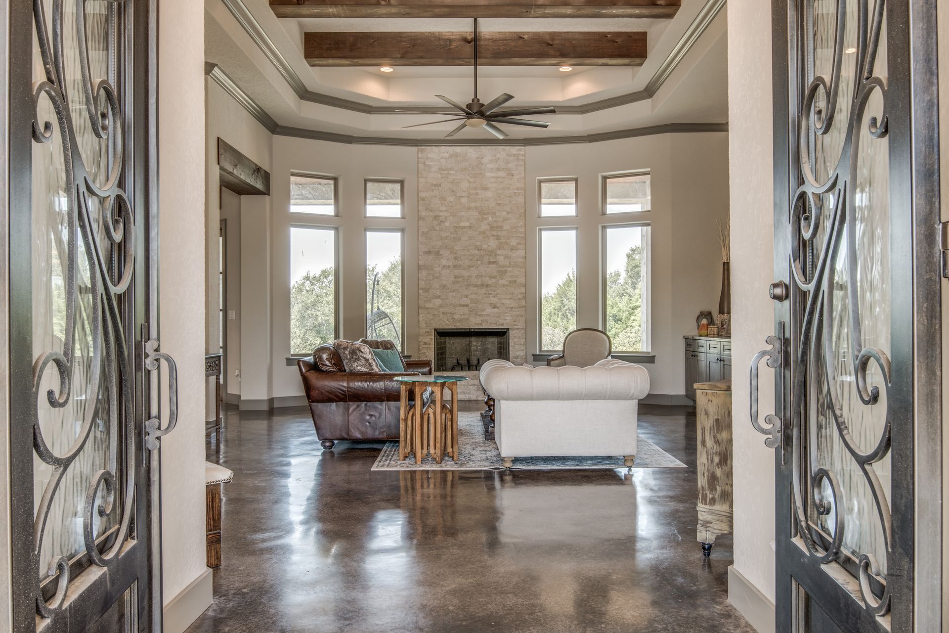 A living room with a couch , fireplace , and ceiling fan.