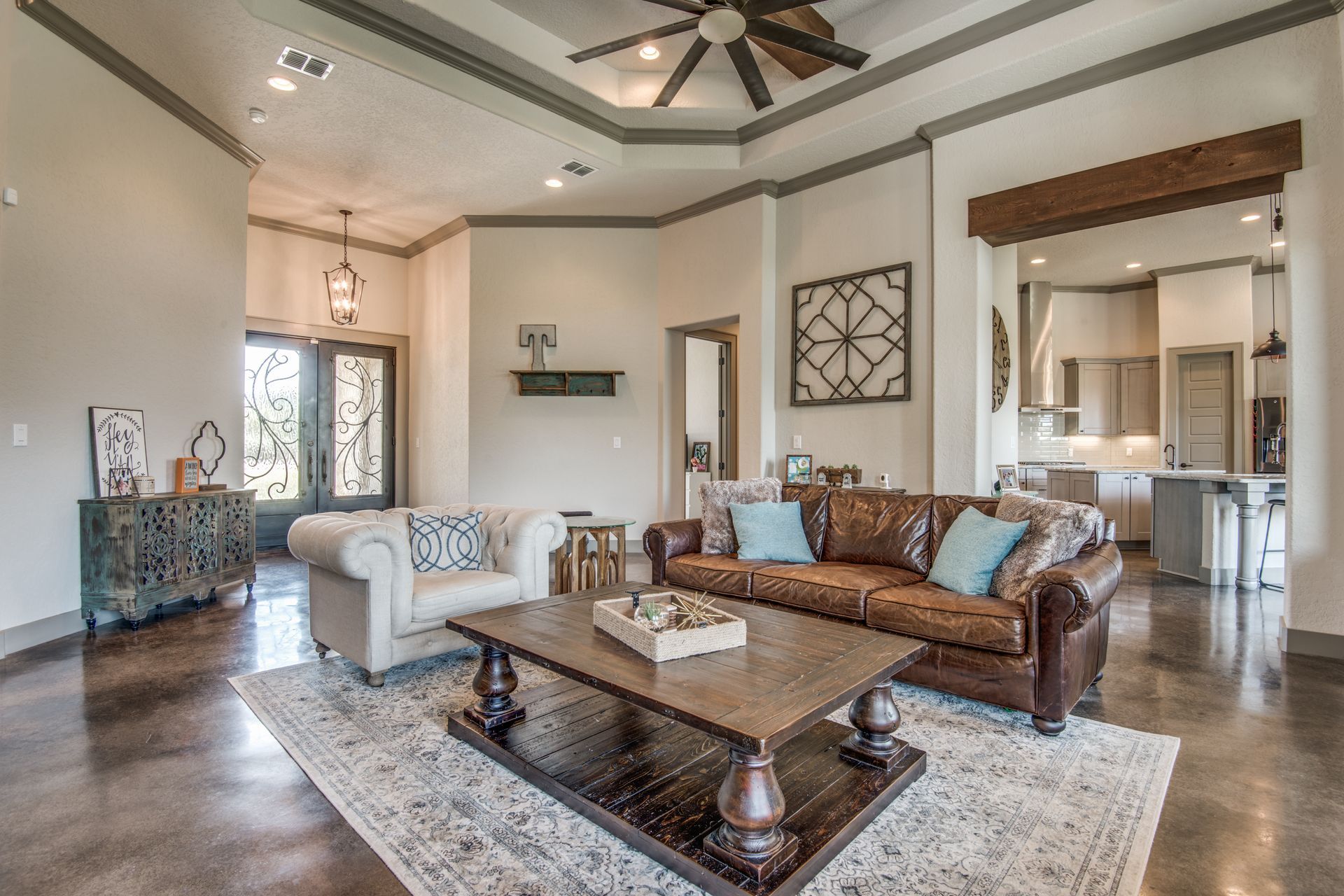 A living room with a couch , chairs , coffee table and ceiling fan.