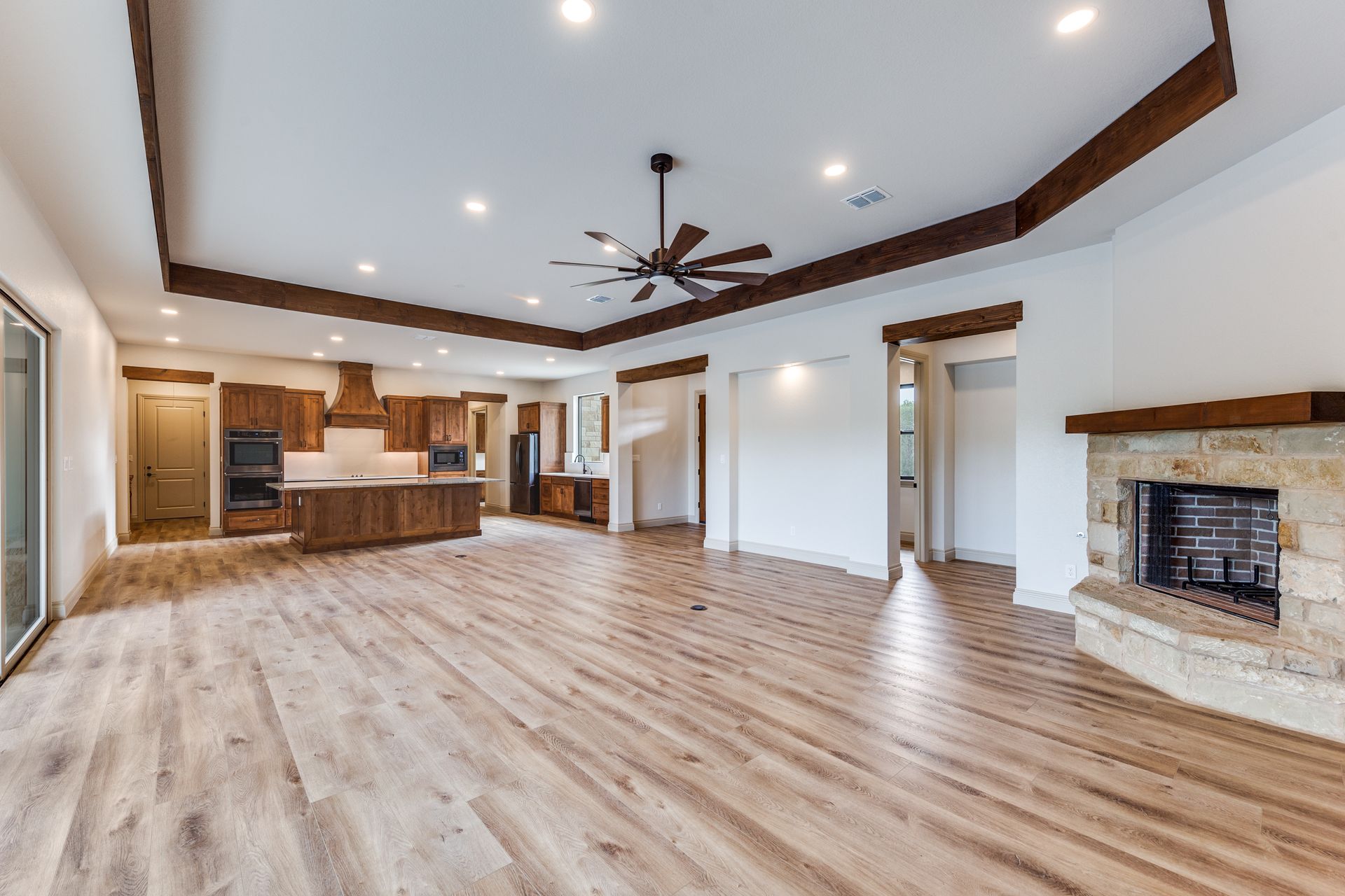 An empty living room with hardwood floors and a fireplace.