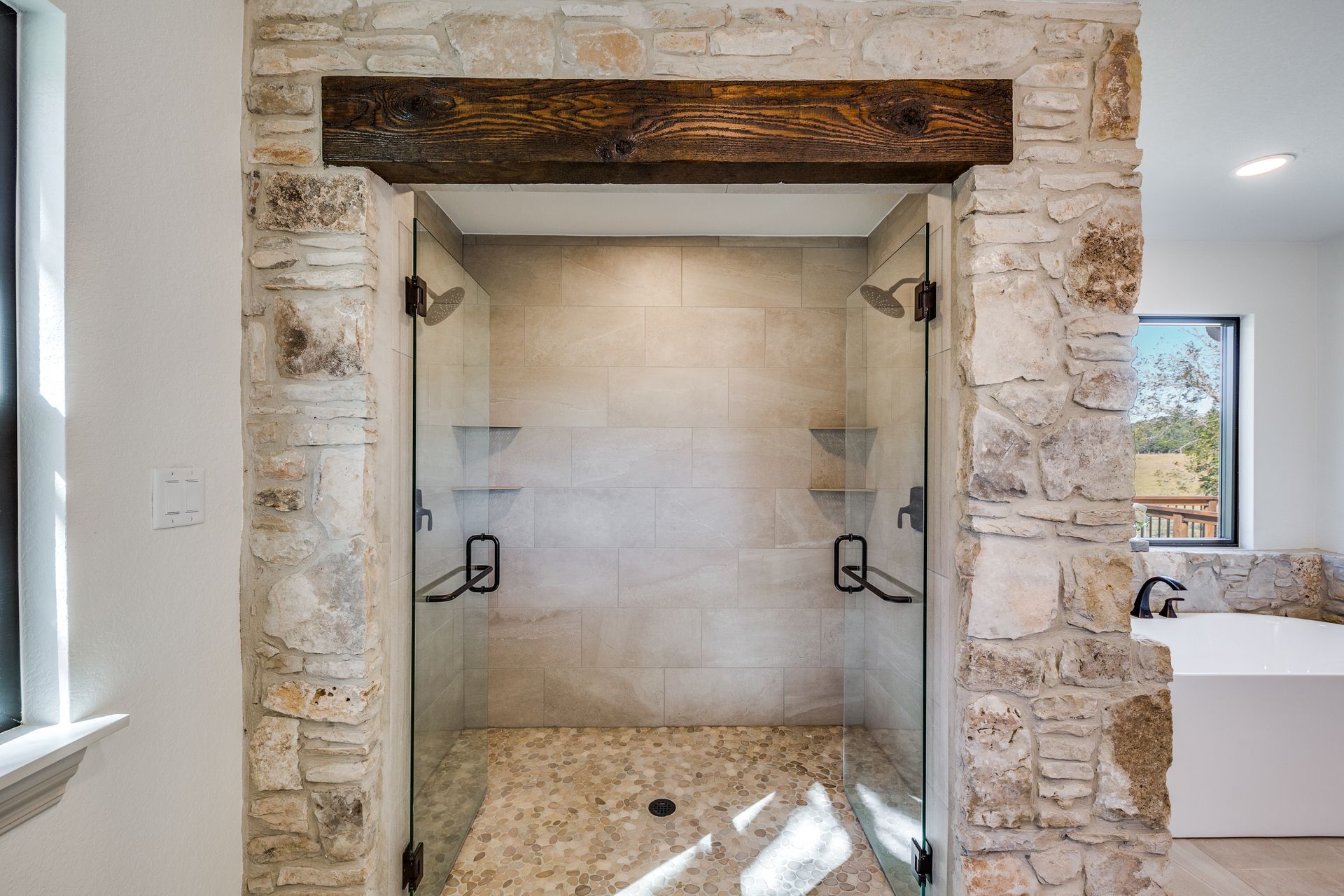 A bathroom with a walk in shower and a bathtub.