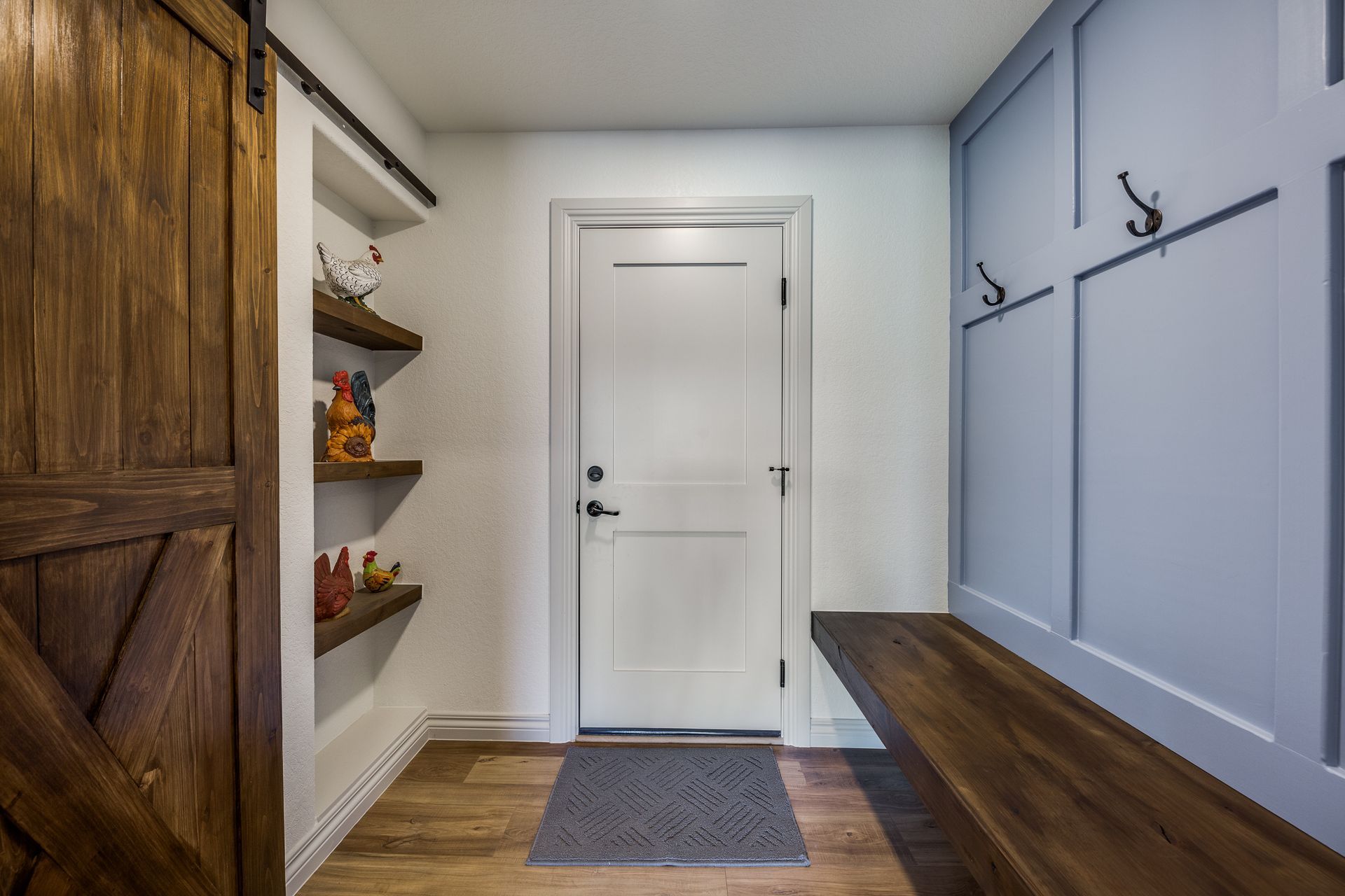 A hallway with a white door and a wooden bench.
