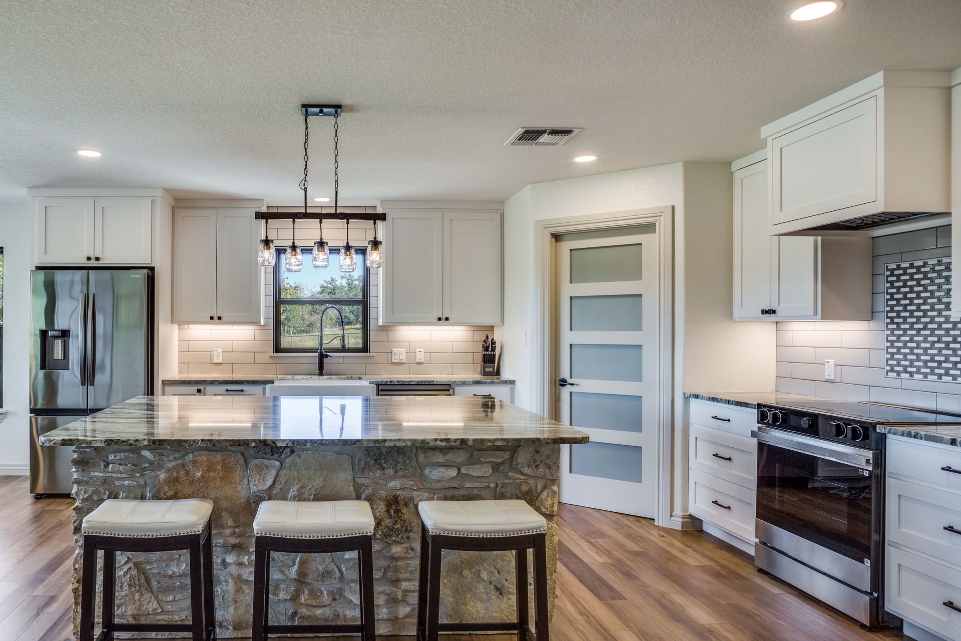 A kitchen with white cabinets and stainless steel appliances