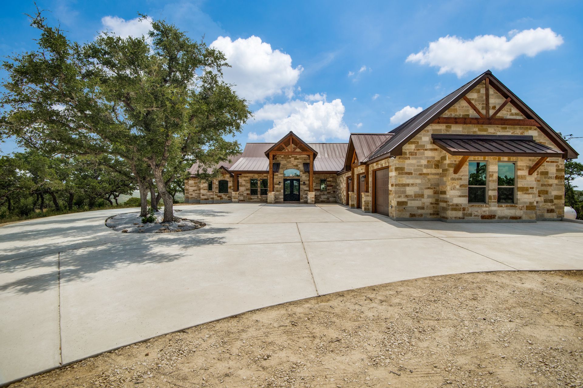 A large stone house with a tree in front of it.