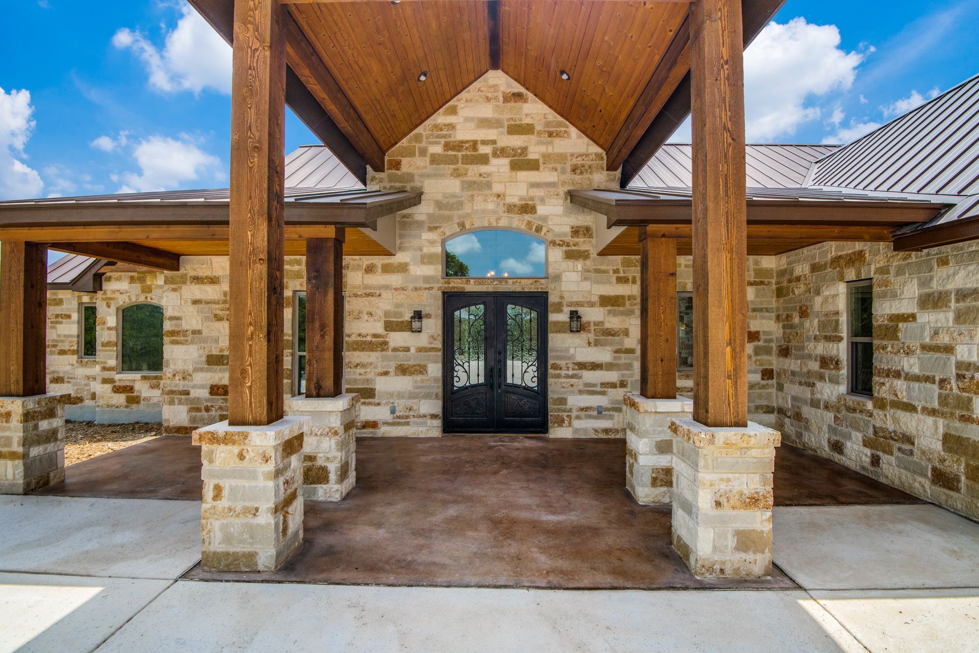 A large brick building with a wooden porch and a metal roof.