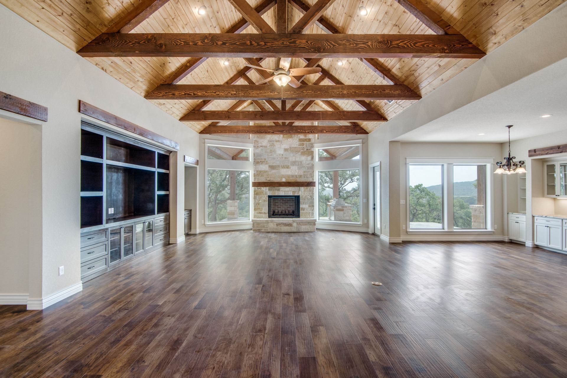 A large empty living room with hardwood floors and a fireplace.