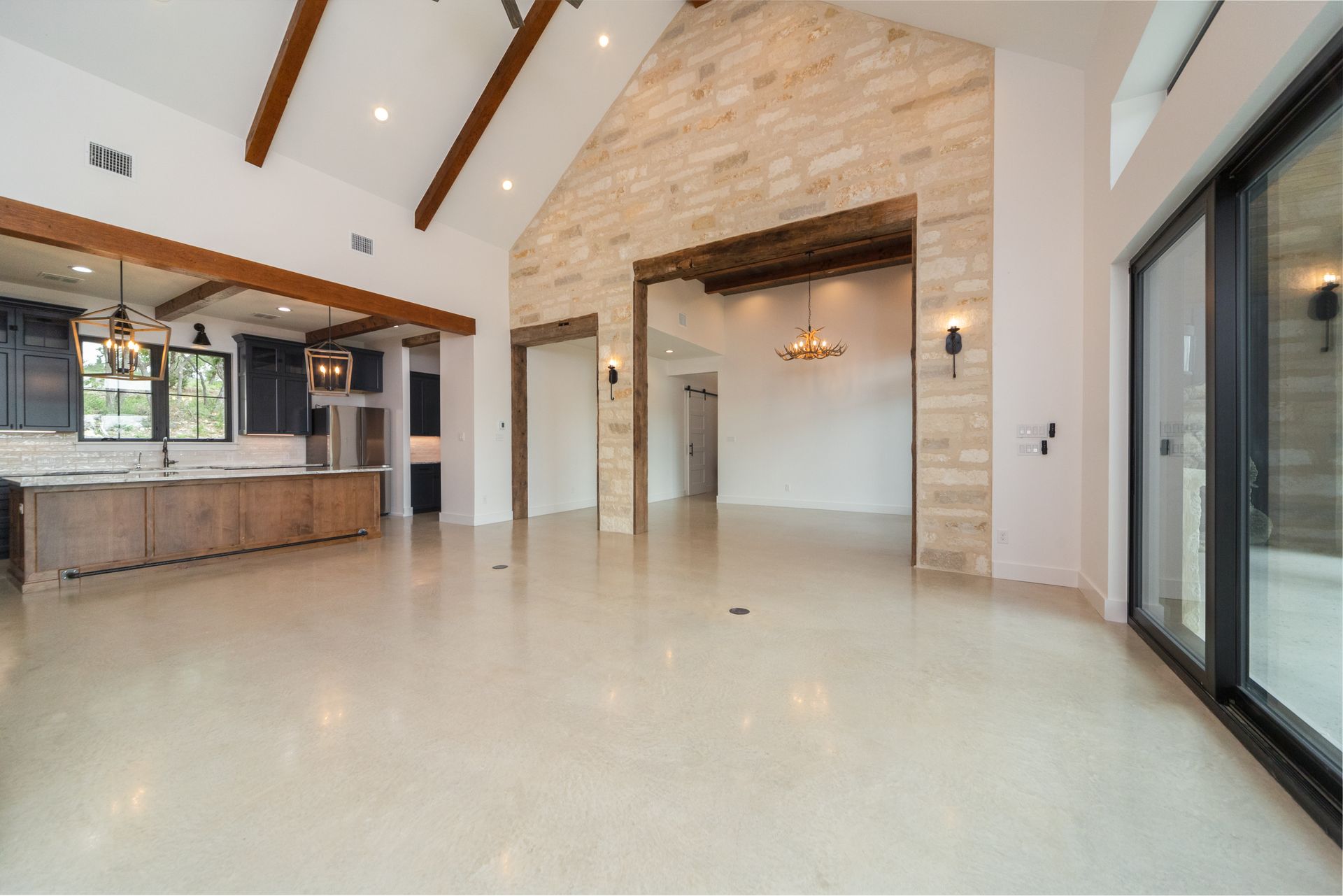 A large empty room with a brick wall and sliding glass doors.