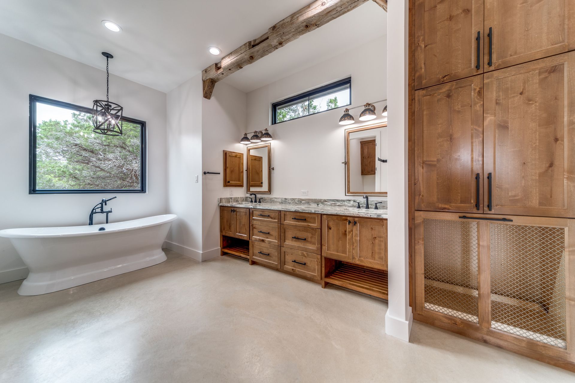 A bathroom with a tub , sinks , and cabinets.