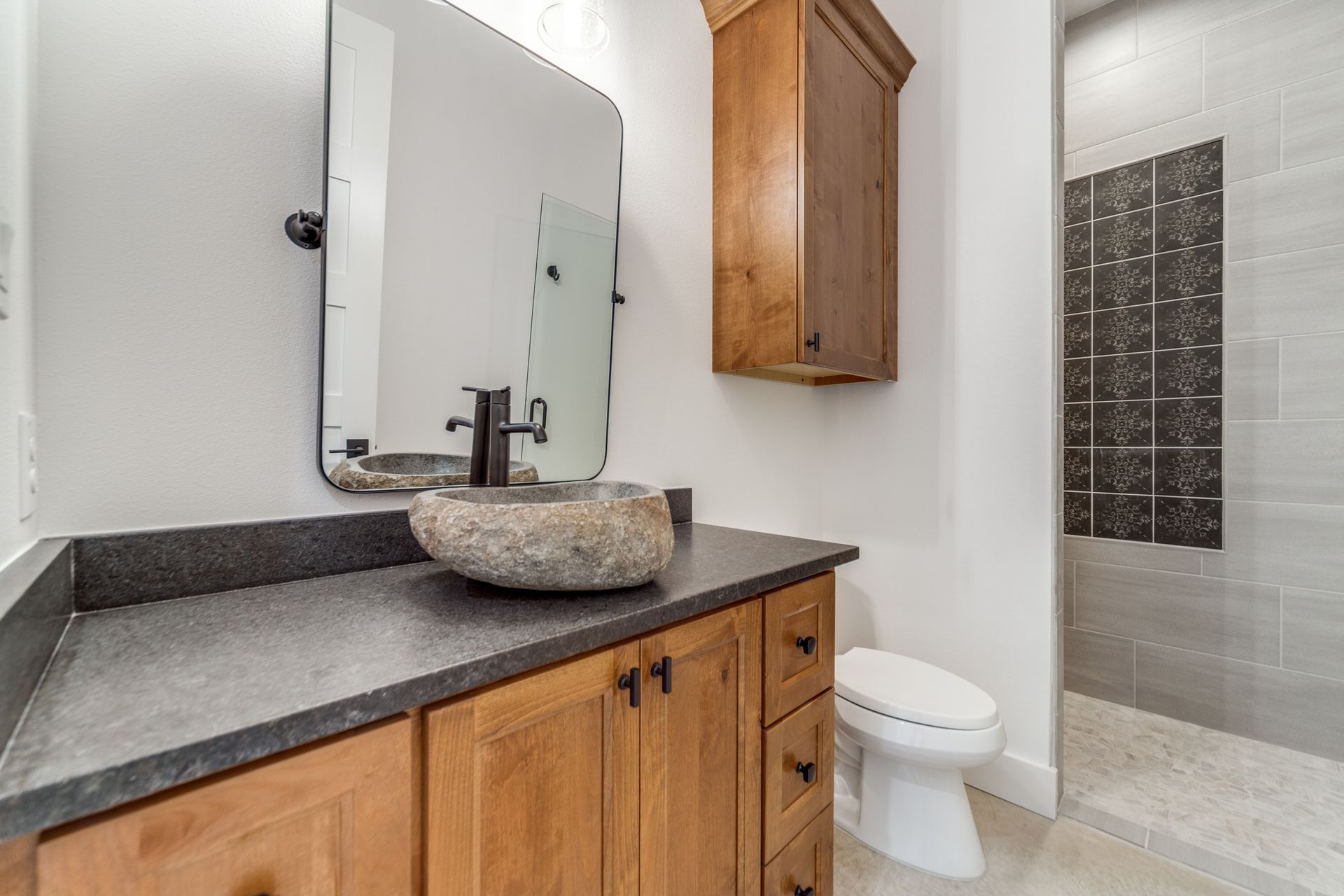 A bathroom with a sink , toilet and mirror.