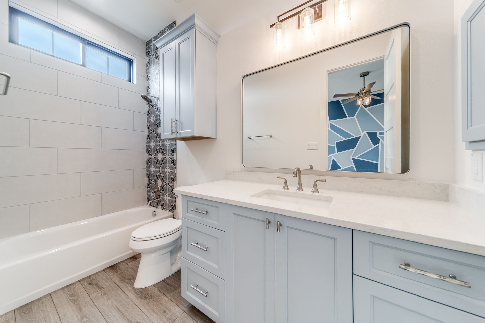 A bathroom with a toilet , sink , and mirror.
