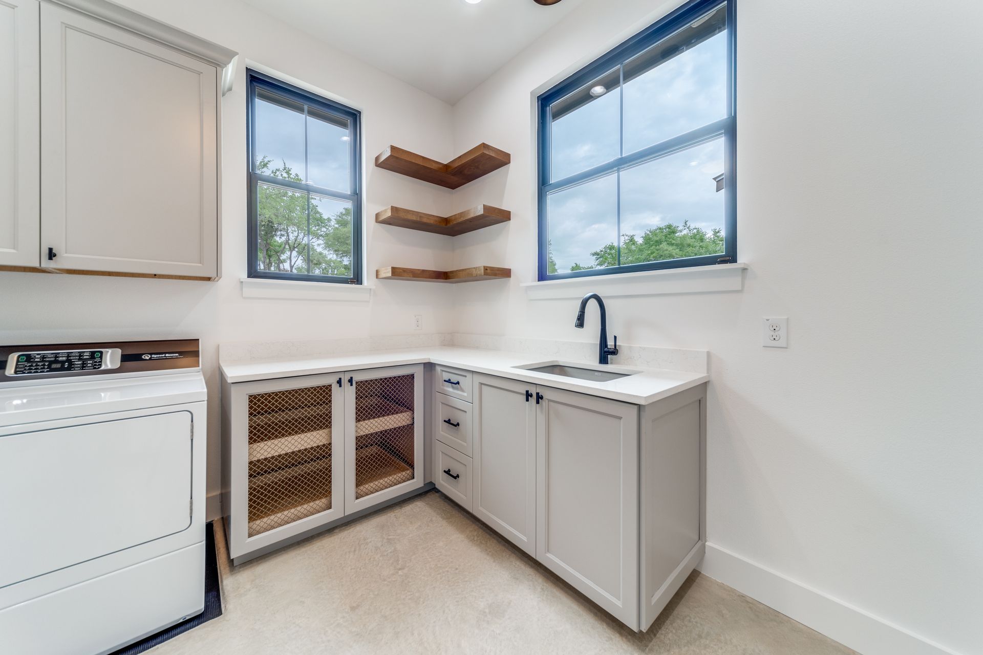A laundry room with a washer and dryer and a sink.