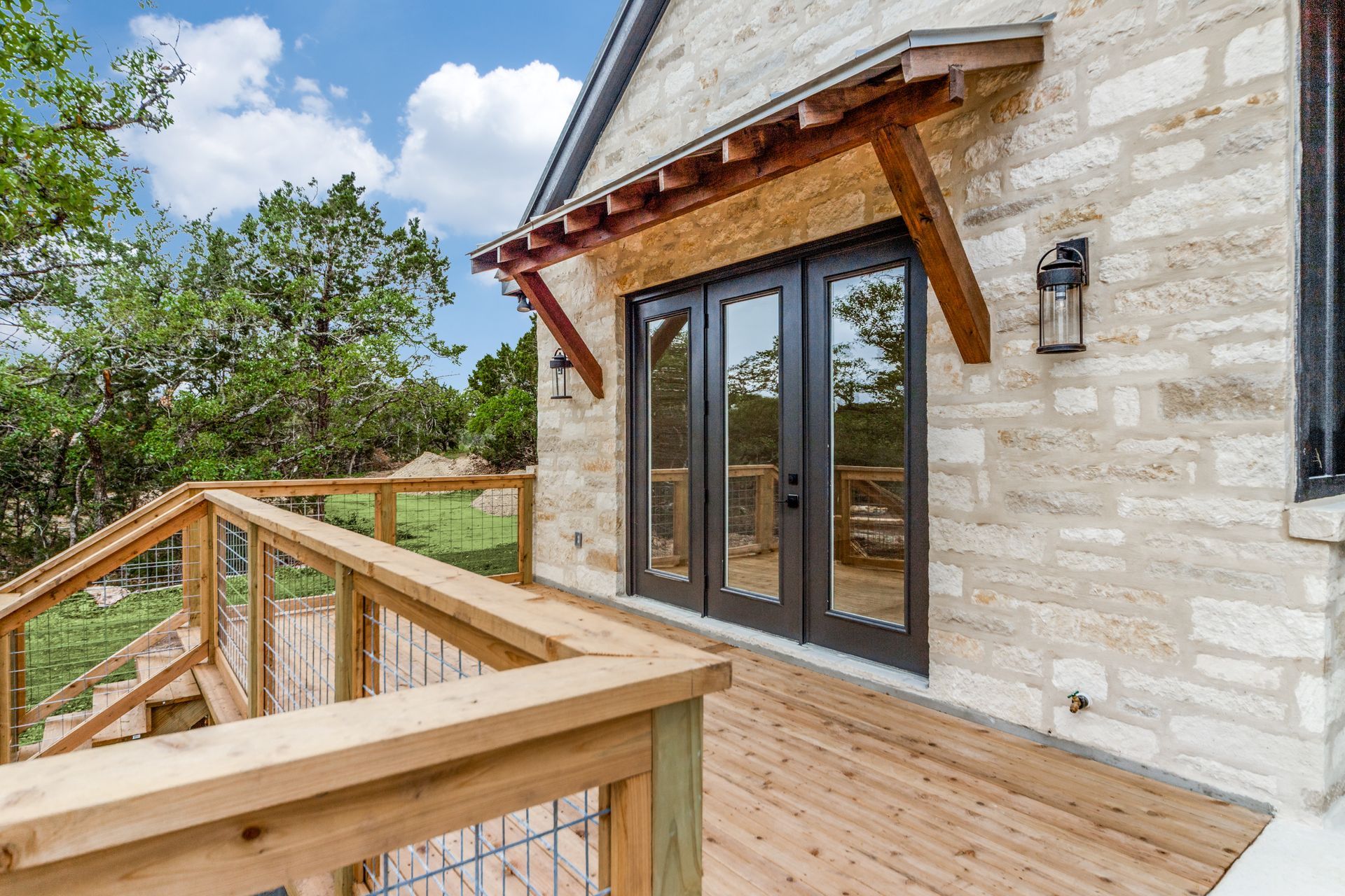 A brick house with a wooden deck and stairs leading to it.
