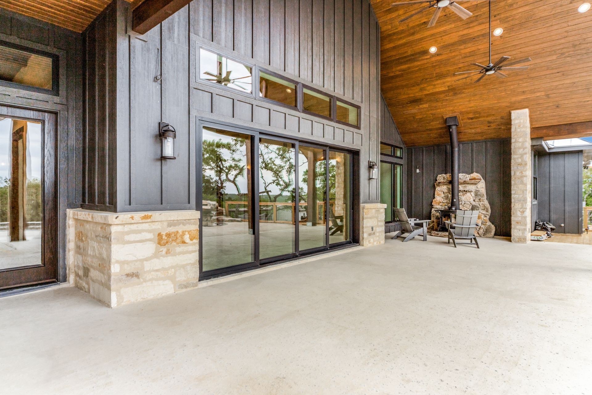 A large patio with sliding glass doors and a wooden ceiling.