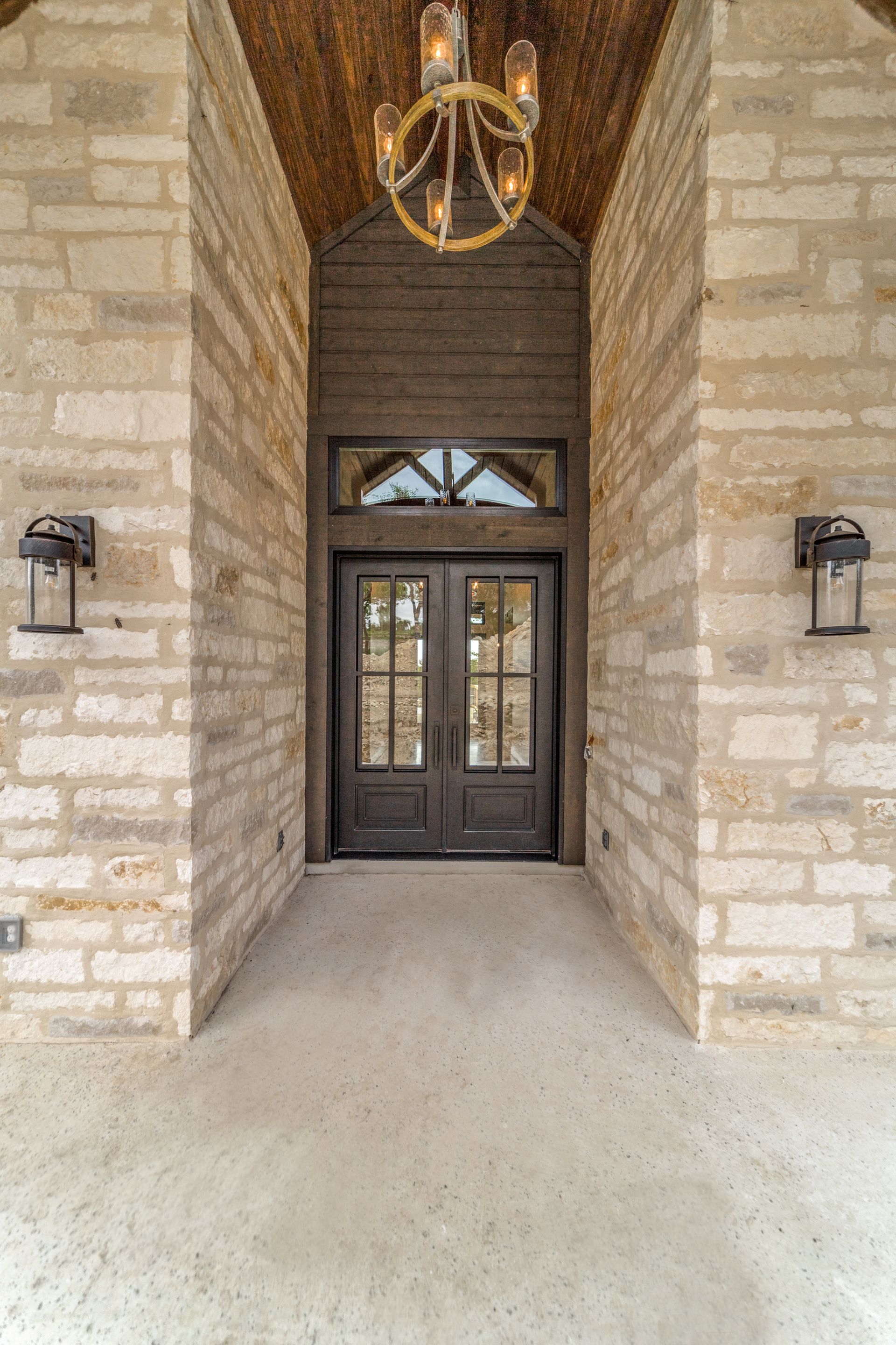A brick building with a double door and a chandelier hanging from the ceiling.