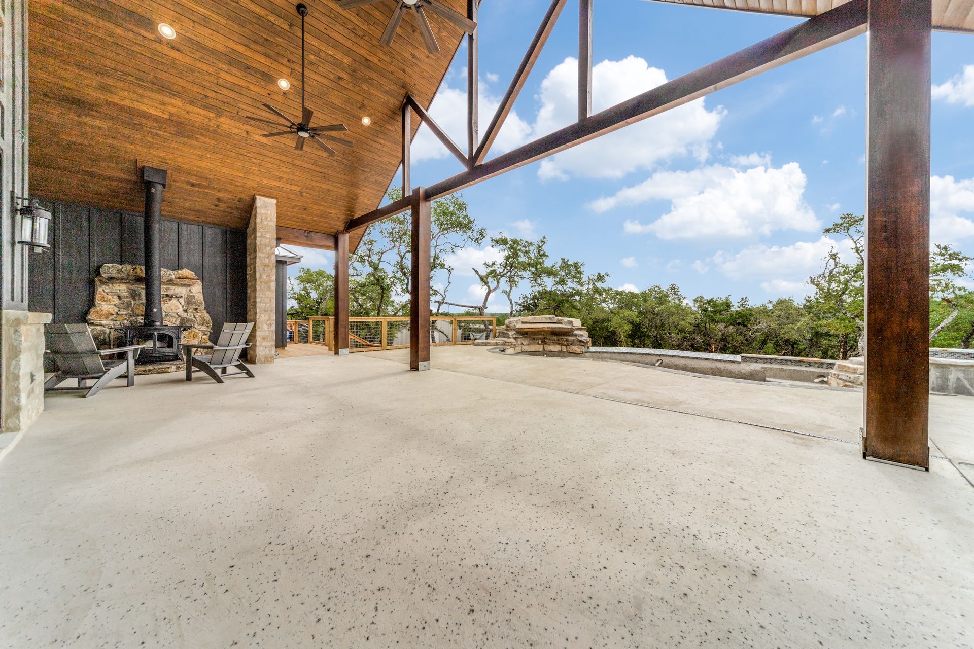 A large covered patio with chairs and a ceiling fan.