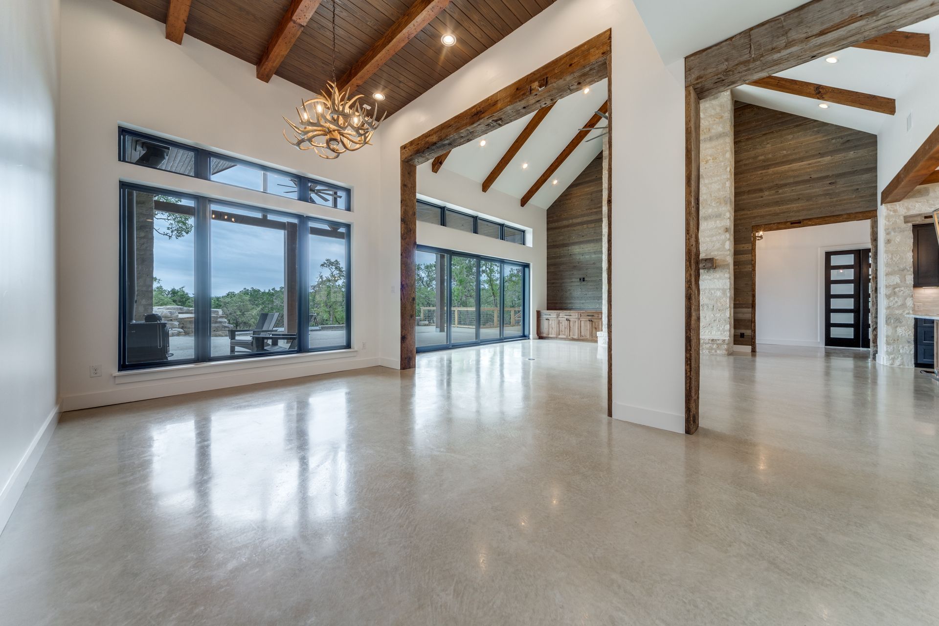 A large empty room with a lot of windows and a chandelier.