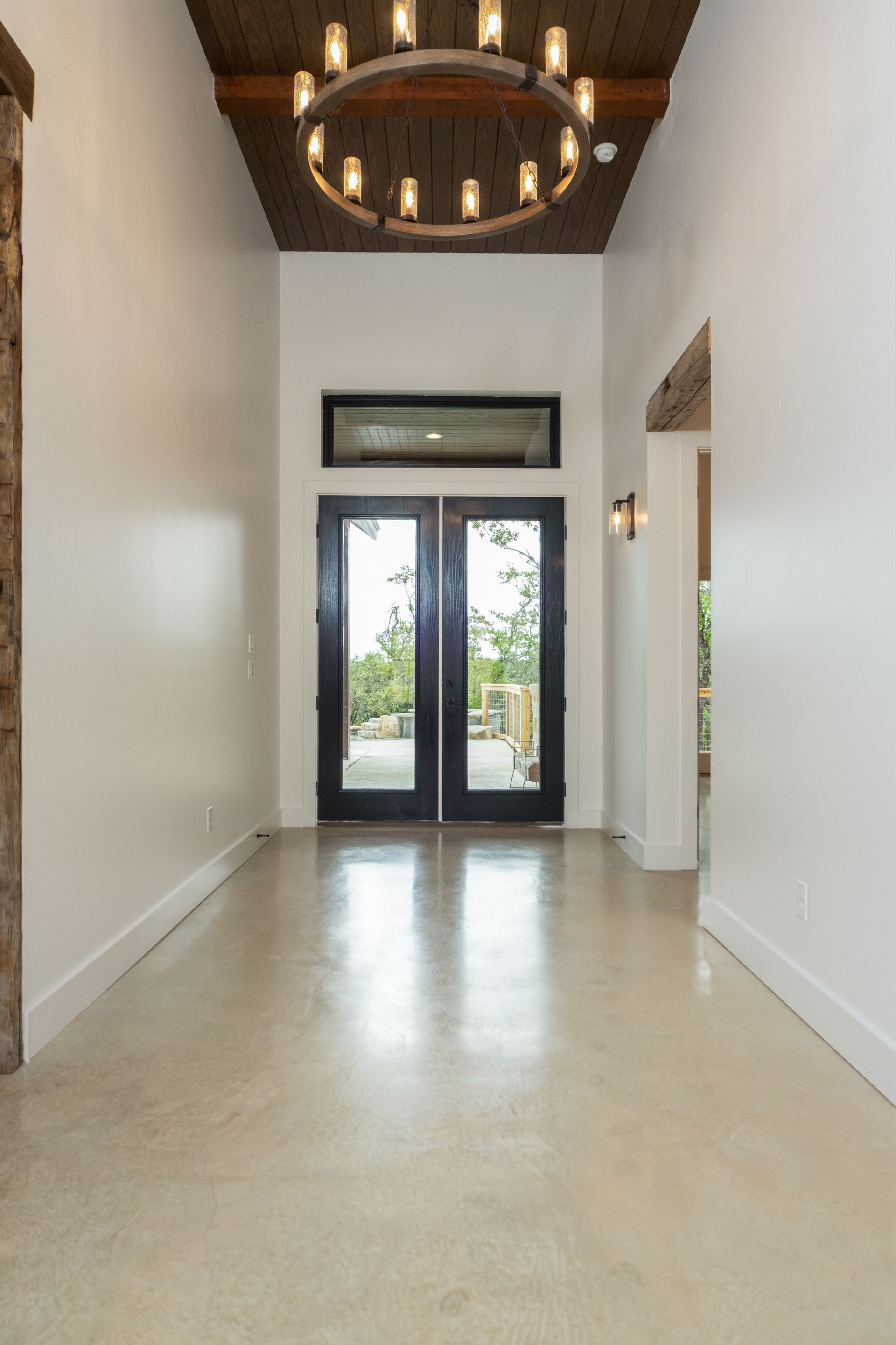 An empty hallway with a chandelier hanging from the ceiling.