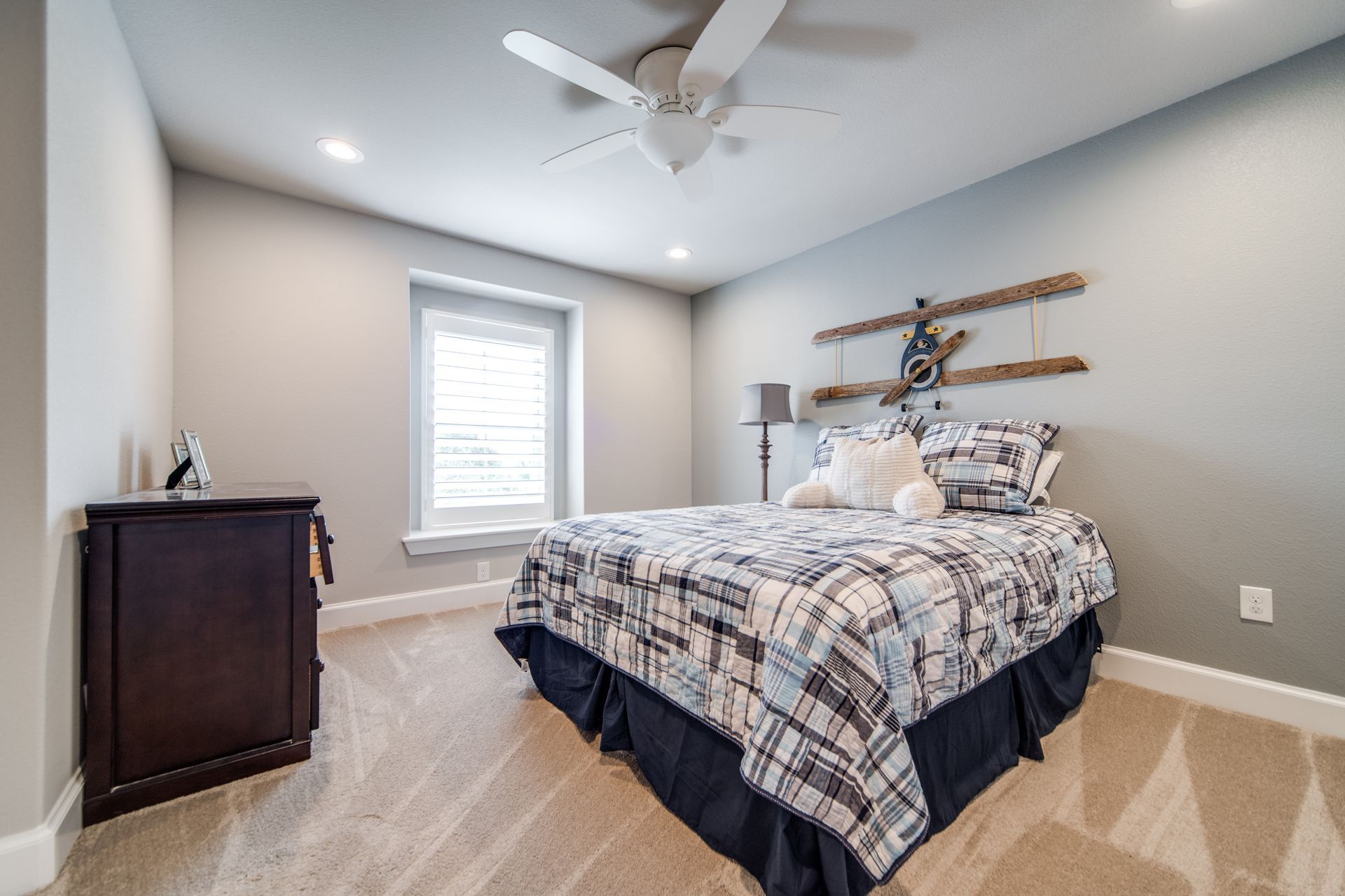 A bedroom with a bed and a ceiling fan.