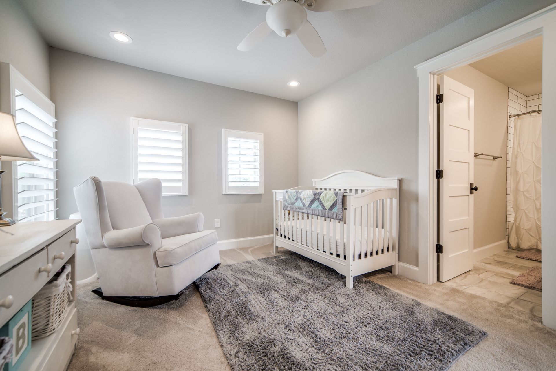 There is a crib and a rocking chair in the room.