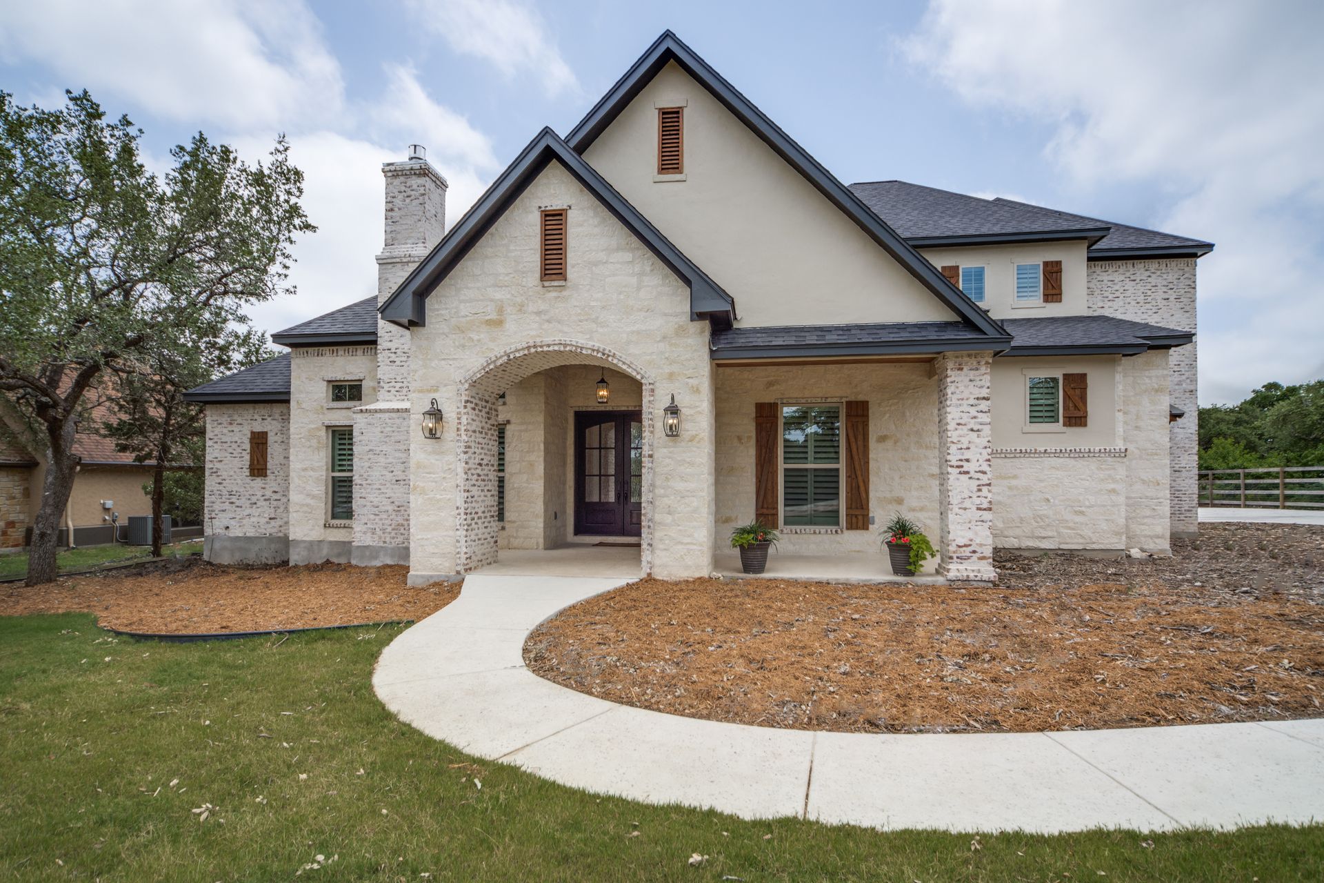 A large white brick house with a black roof