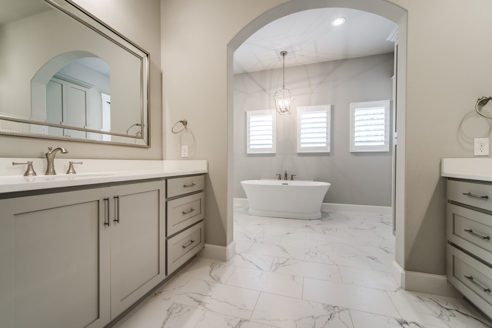 A bathroom with two sinks , a tub and a mirror.