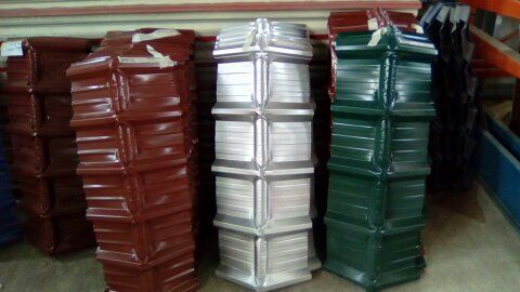 Pilas de tejas metálicas de color rojo, plateado y verde.