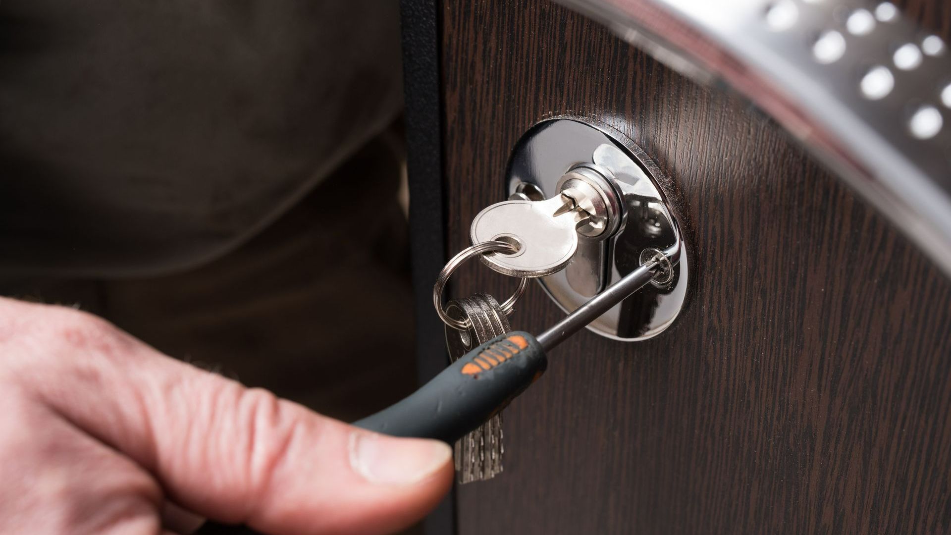 A Person Is Fixing a Door Lock with A Screwdriver | Westminster, CO | M.L. Locksmith