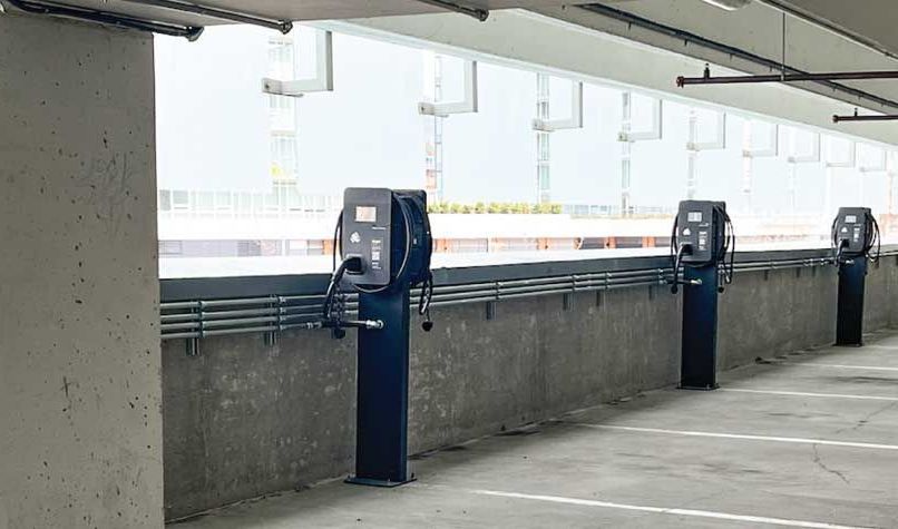 A parking garage with 3 Wattz Up Standard pedestals with dual chargers.