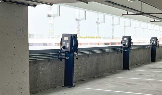 Four Standard Wattz Up EV Charging Pedestals hold two EV chargers each in public parking.