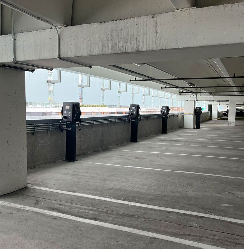 Four Standard Wattz Up EV Charging Pedestals hold two EV chargers each in multi-level public parking.