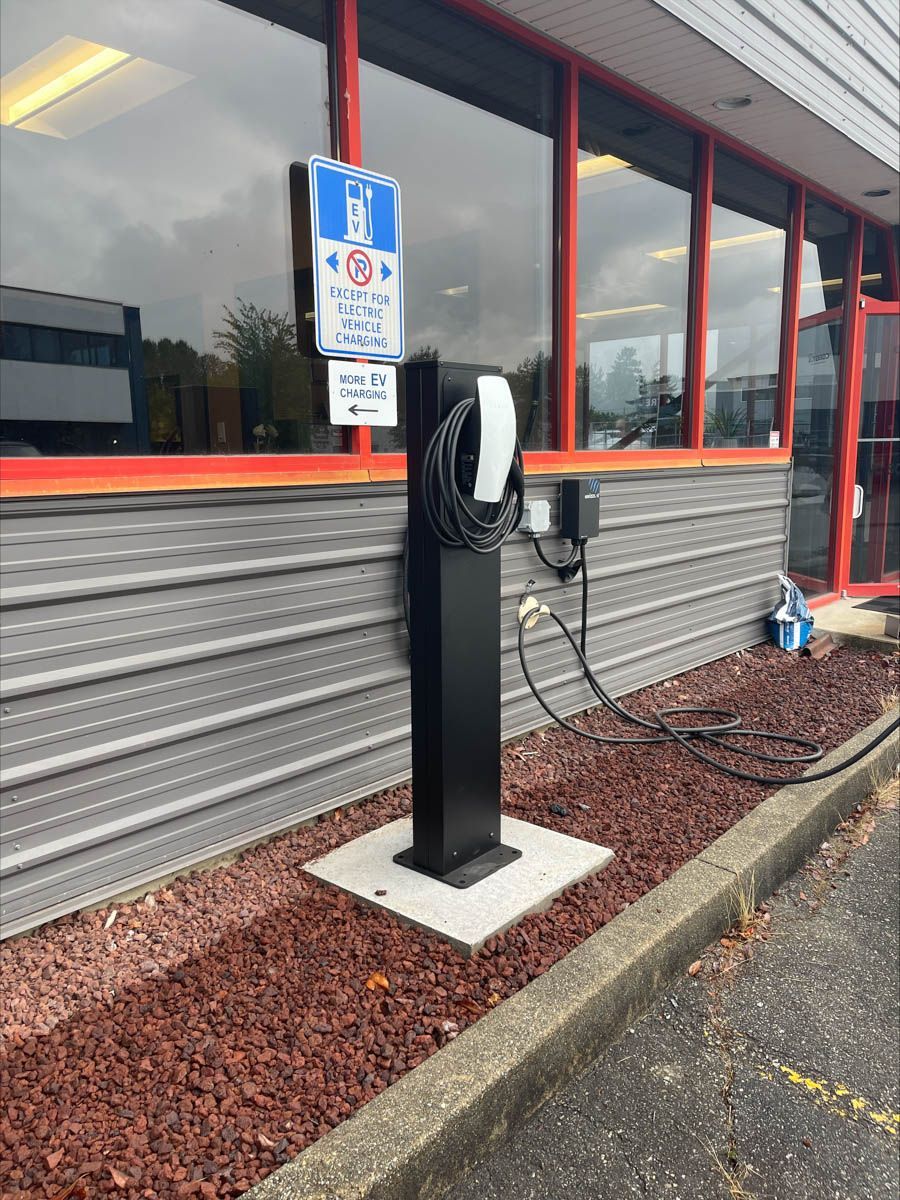 The Standard Wattz Up EV Charging Pedestal is installed in front of a building.