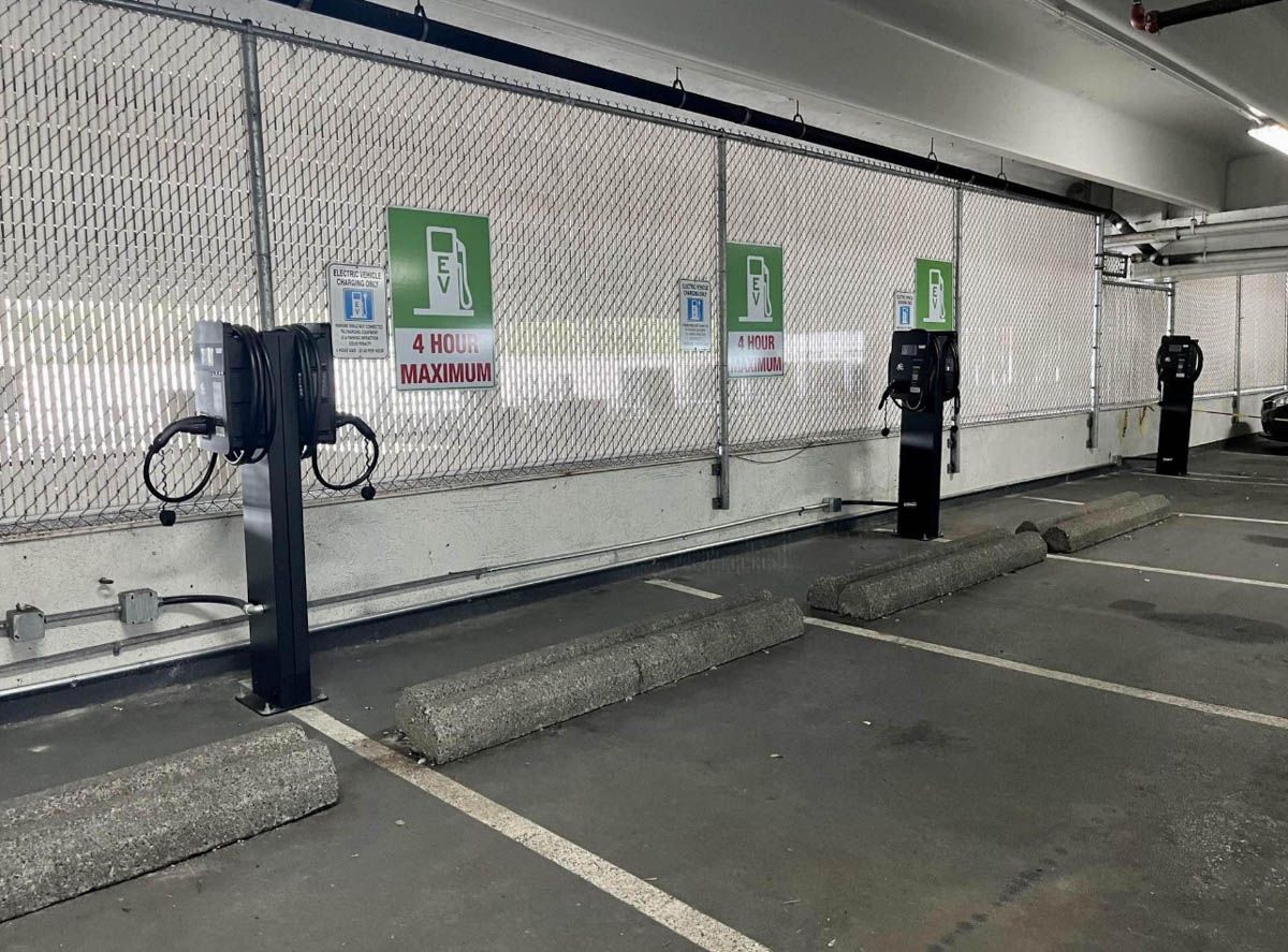 A parking garage with 3 Wattz Up Standard pedestals with dual chargers.