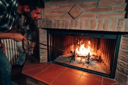 Man Is Checking The Fire At The Fireplace - Elizabeth City, North Carolina - Albemarle Chimney Sweep