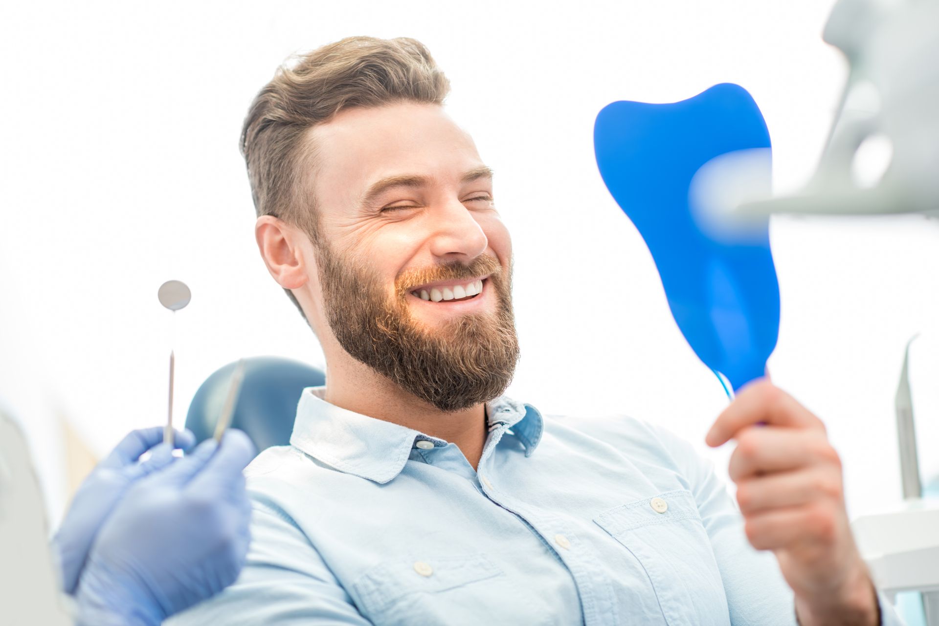 A male patient looking at his beautiful smile sitting at the dental office. A male patient looking at his beautiful smile sitting at the dental office.