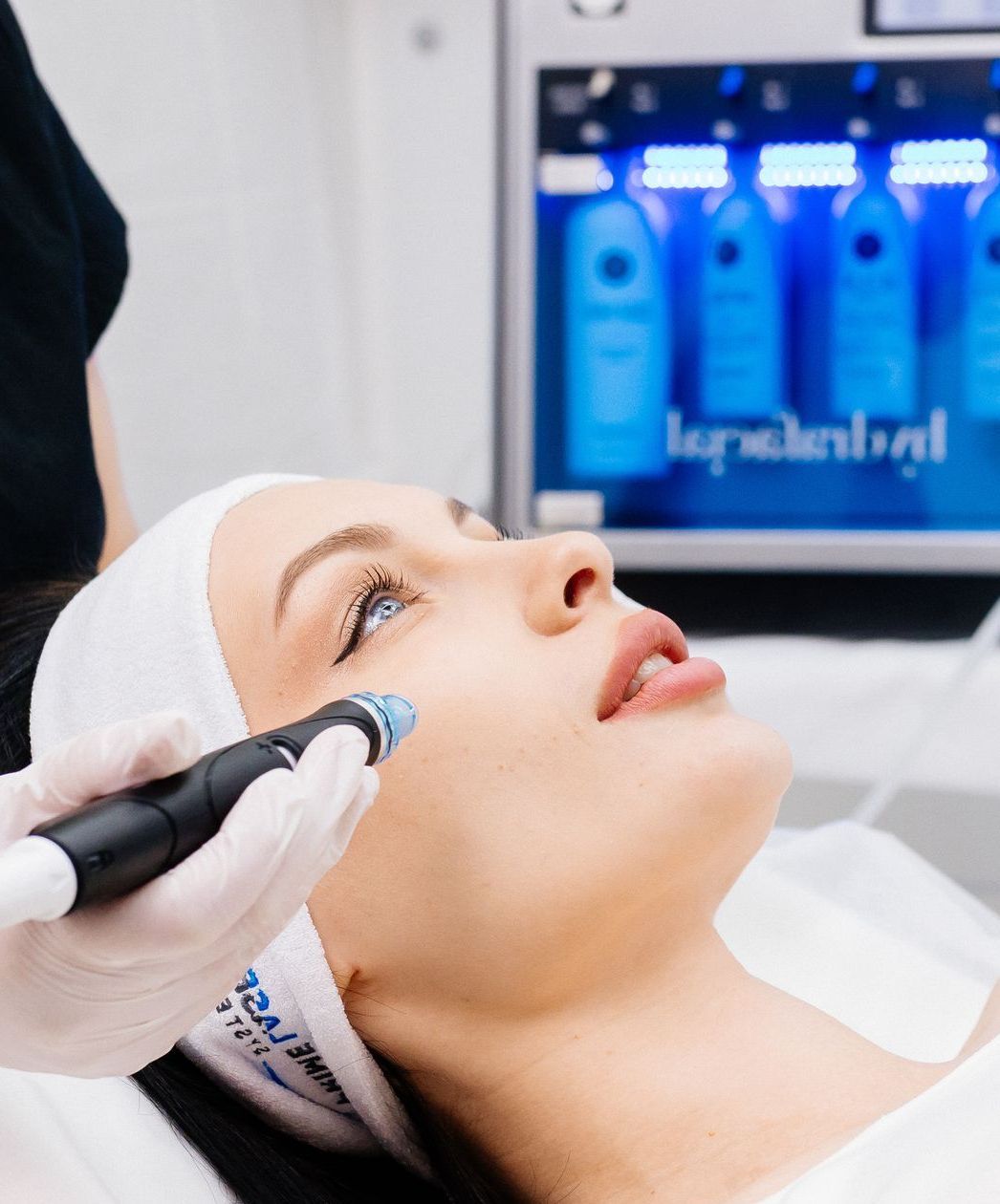 A woman is getting a Hydrafacial™ treatment at a beauty salon