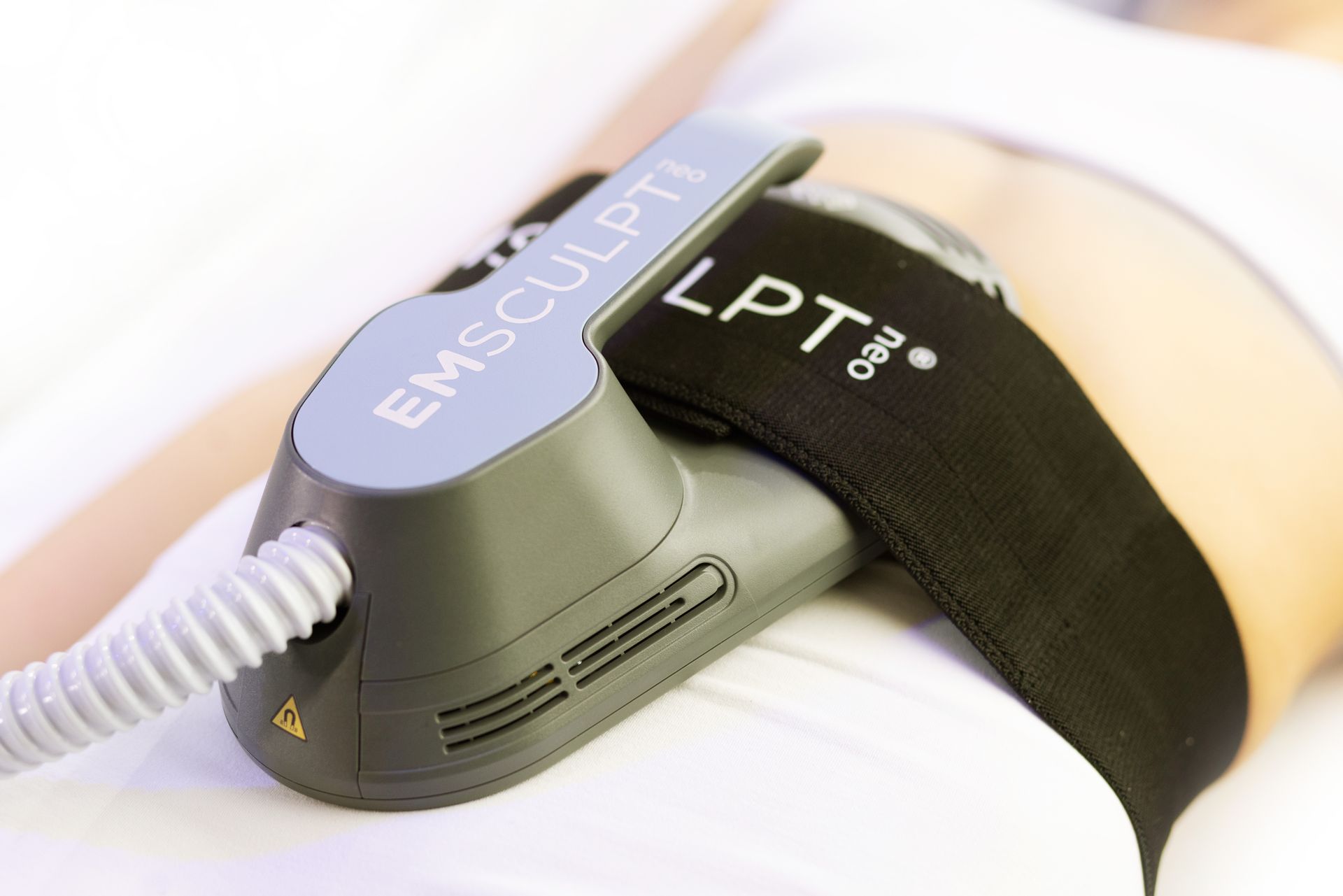 A person is laying on a bed with a machine on their stomach.