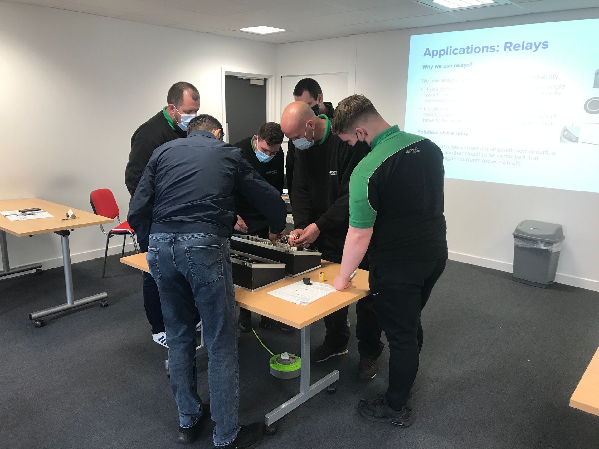 A group of men are standing around a table in a room.