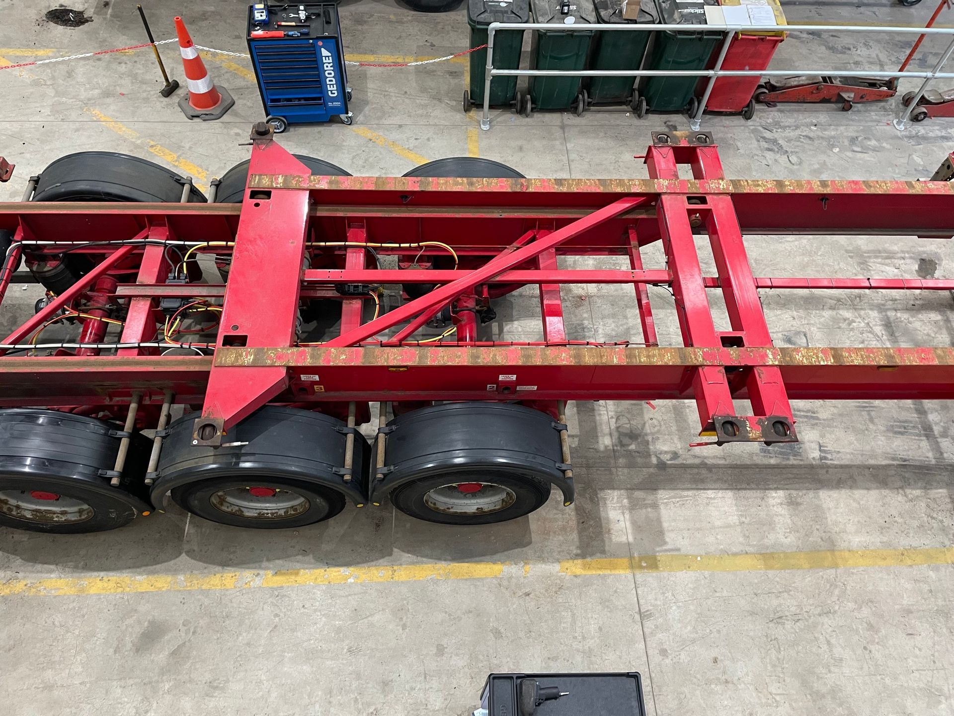 A red trailer is parked in a parking lot.