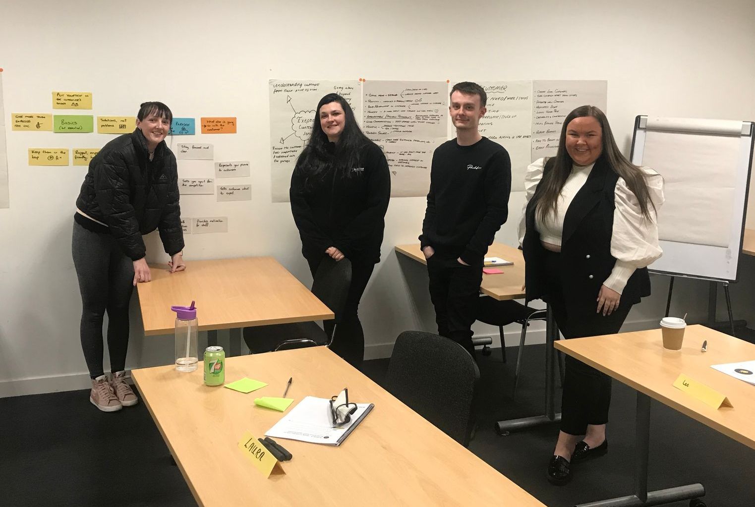 A group of people are standing around a table in a room.