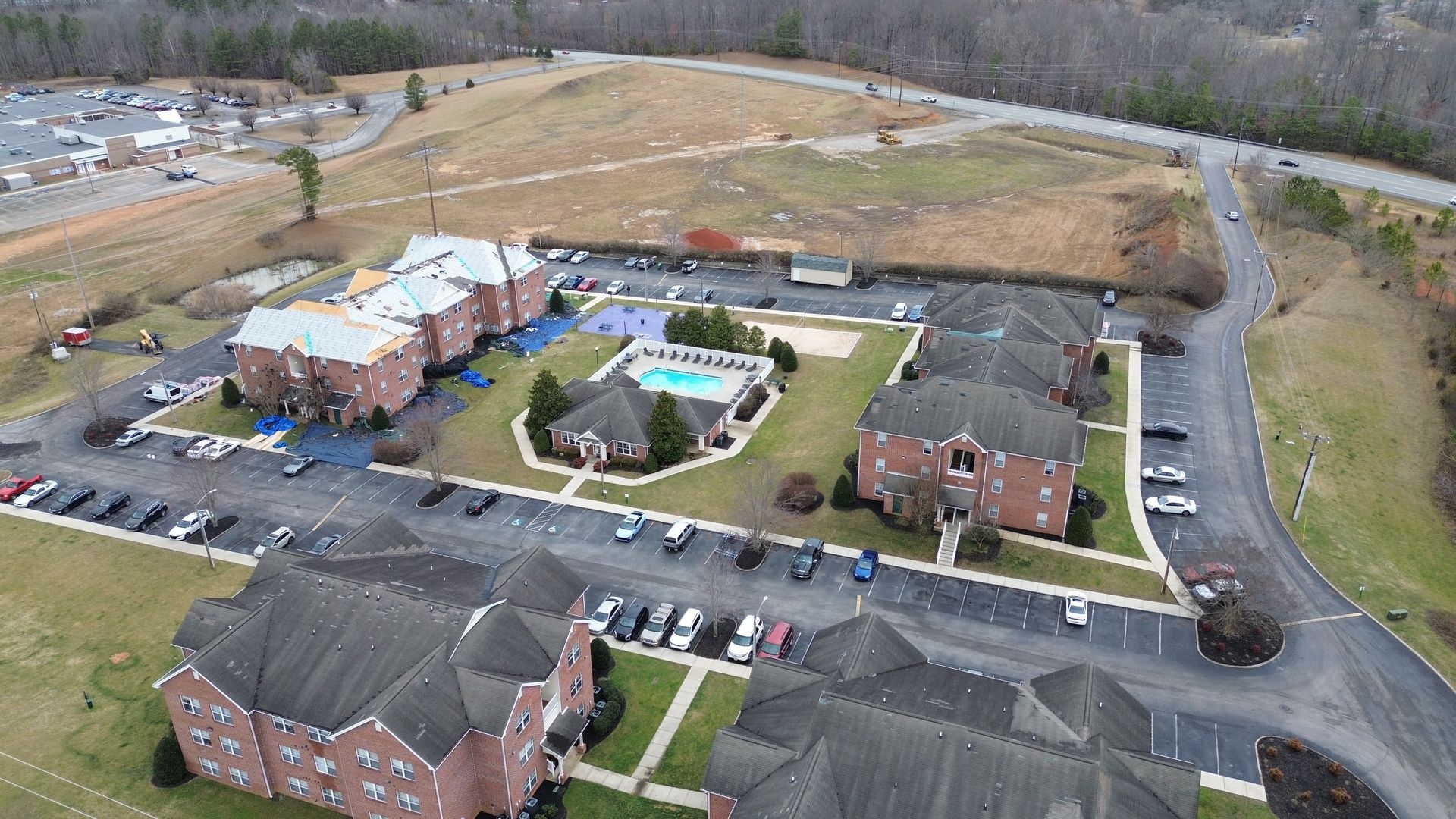 An aerial view of a large apartment complex with a pool in the middle.