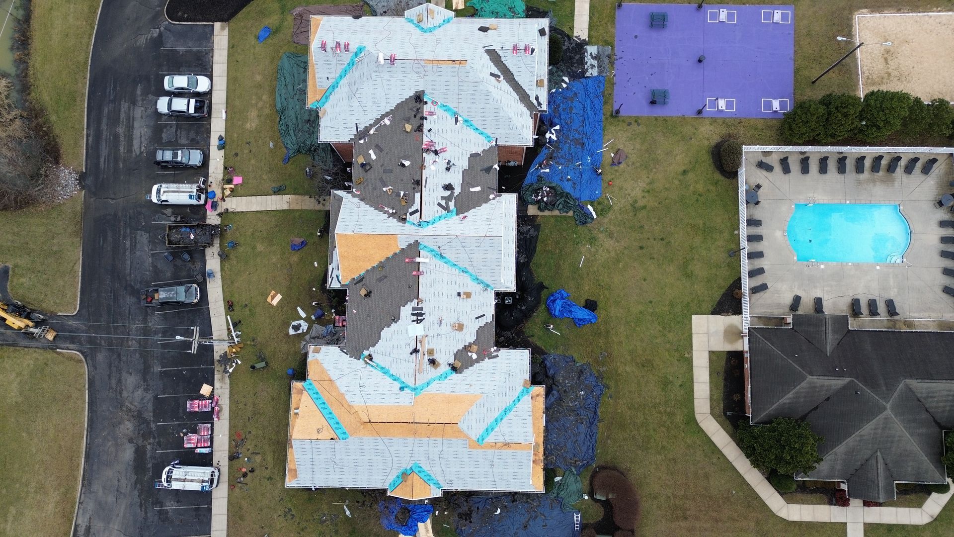 An aerial view of a building under construction with a pool in the background.