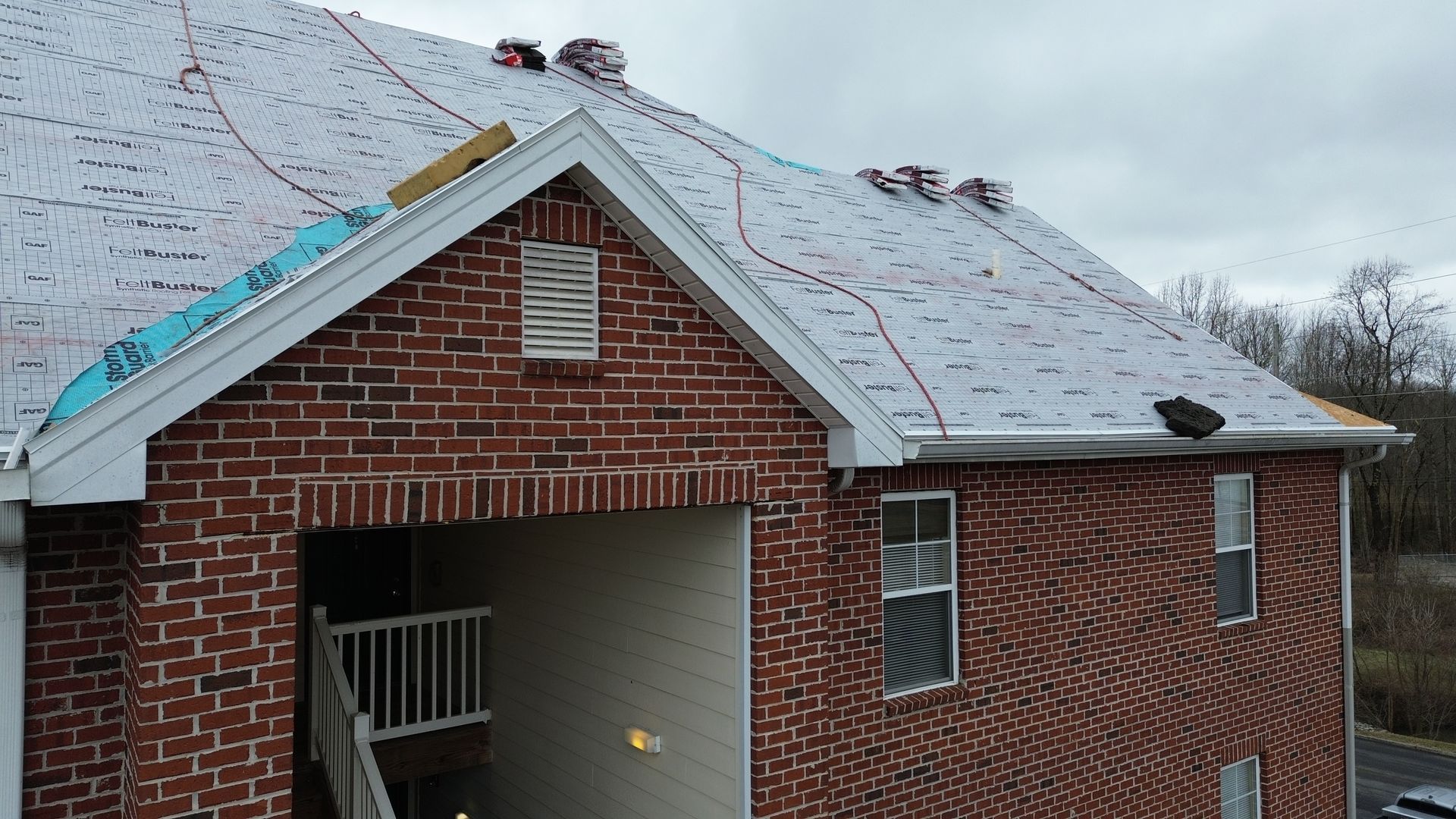A brick house with a roof that is being installed
