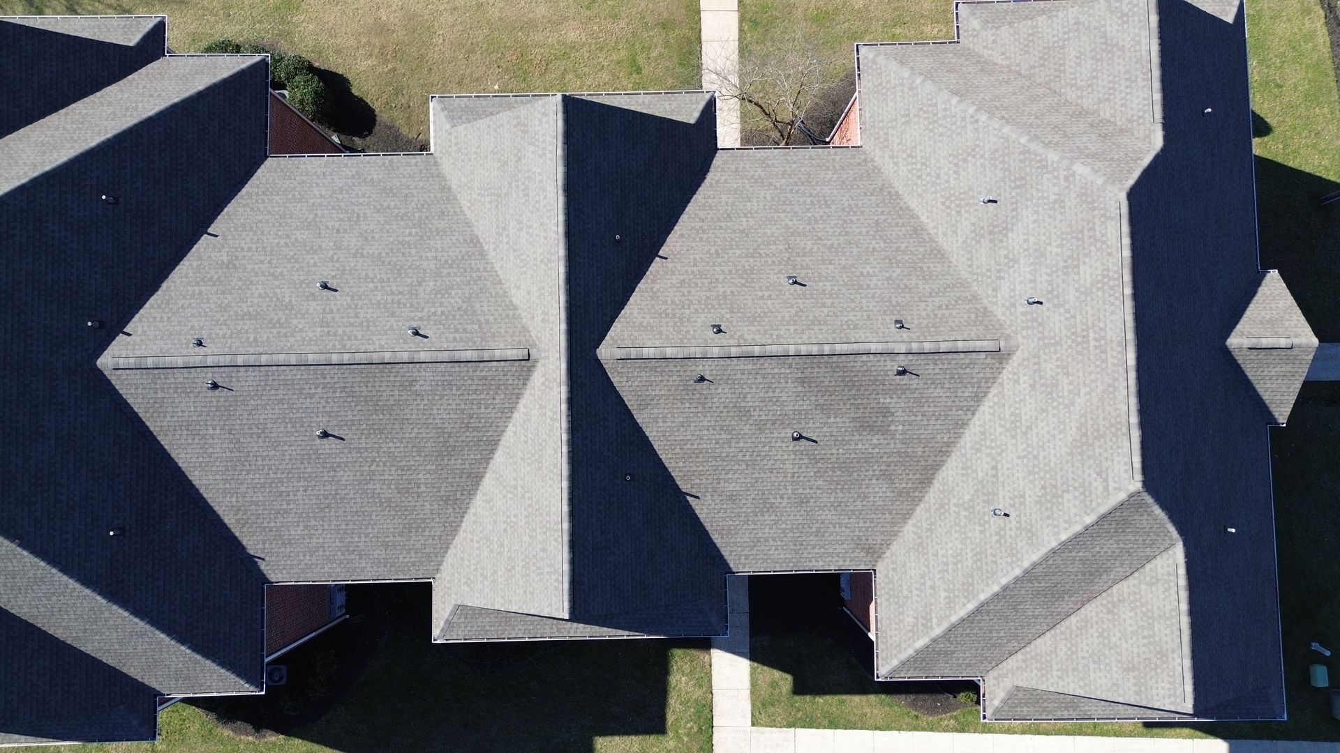 An aerial view of a row of houses with a lot of roofs.