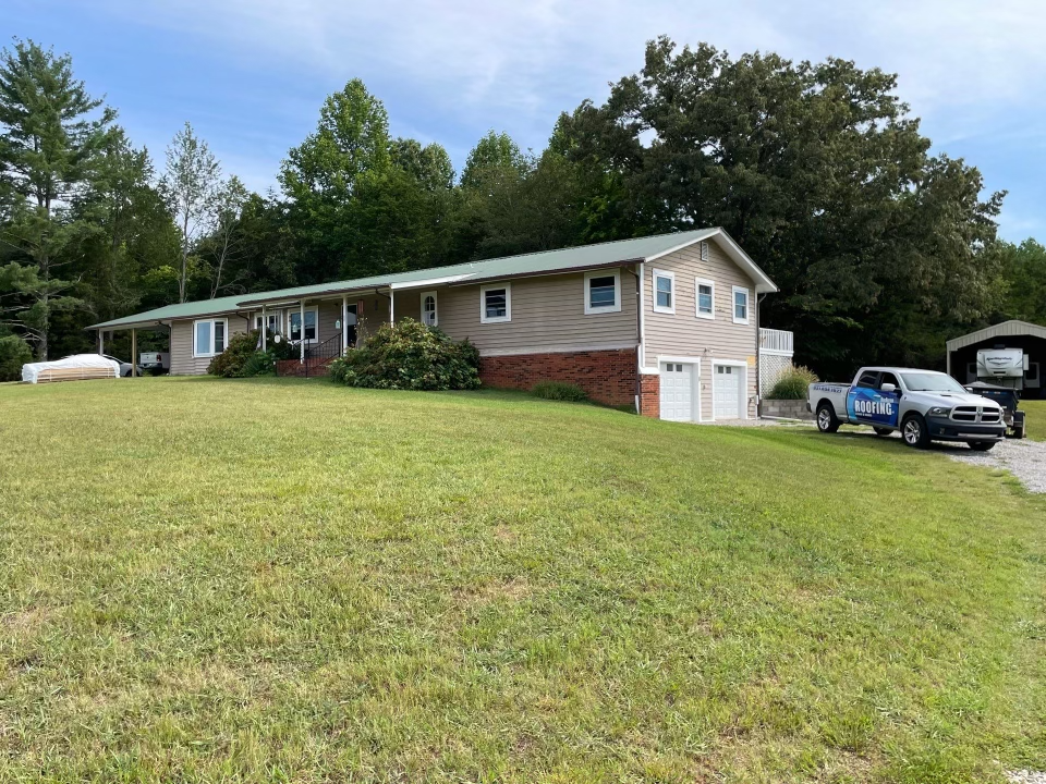 A large house with two trucks parked in front of it.