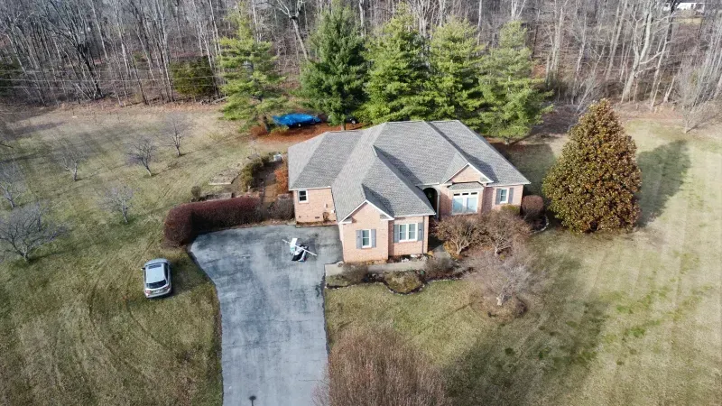 An aerial view of a house with a car parked in front of it.