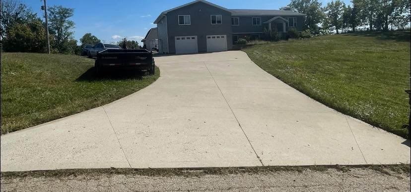 A truck is parked on the side of a driveway in front of a house.