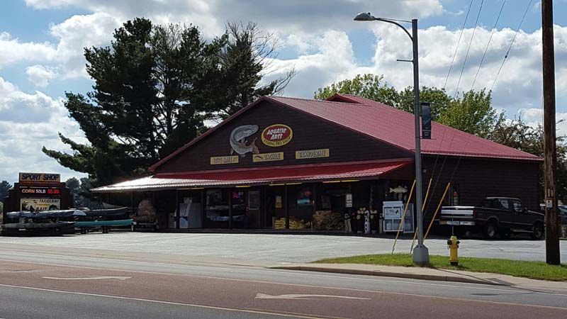 A large brown building with a red roof is sitting on the side of the road.