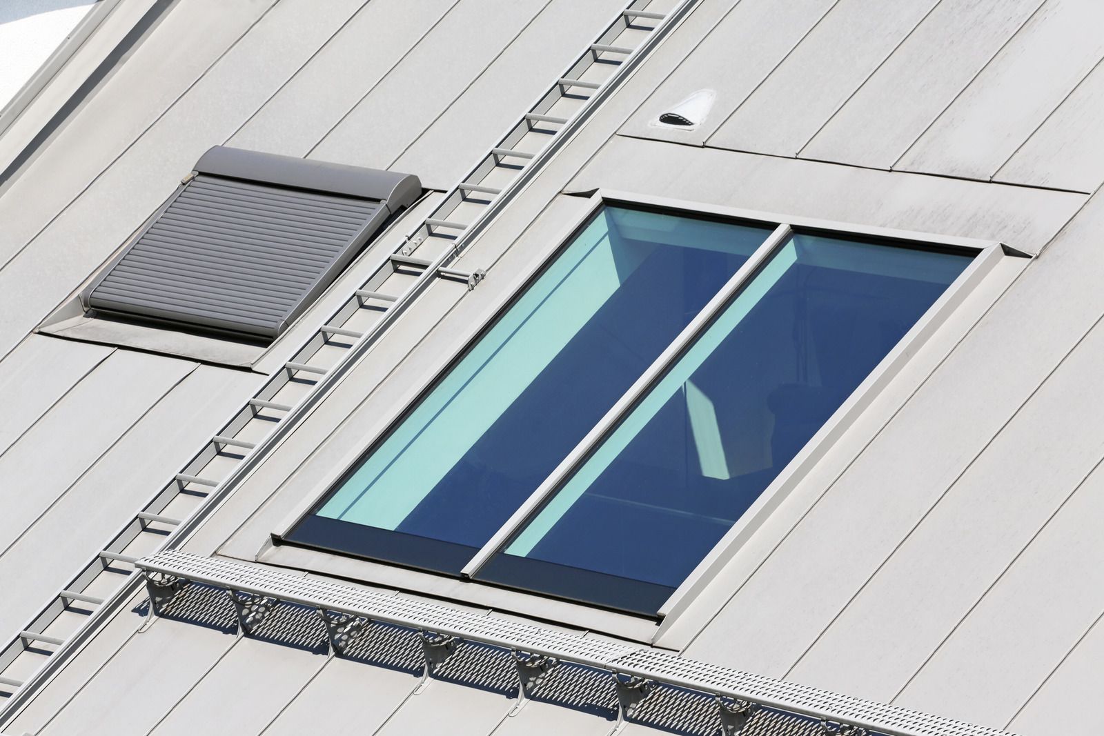 A roof with a window and solar panels on it